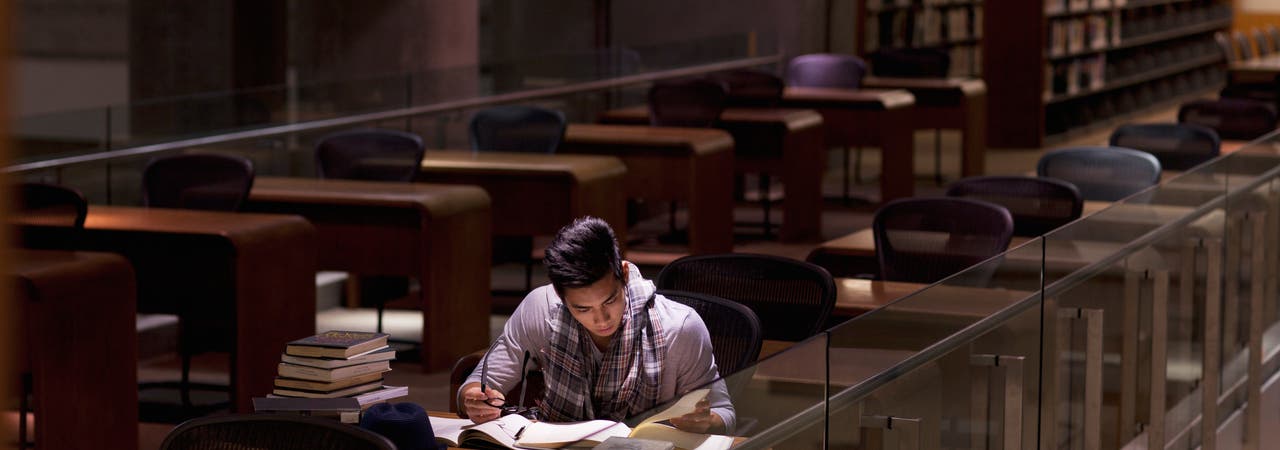 Student lernt spätabends in der Bibliothek 