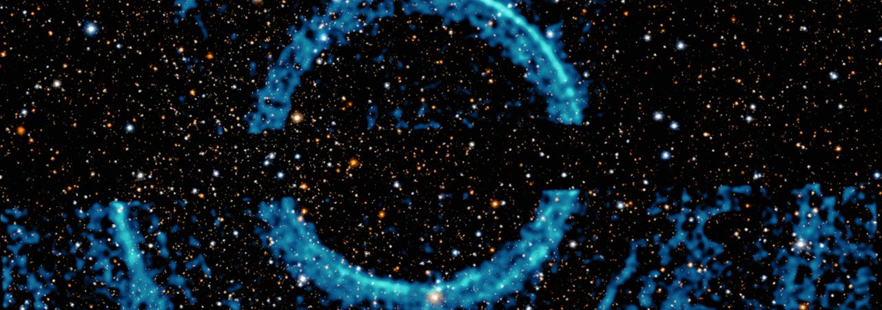 Röntgenechos um V404 Cygni, dargestellt als blaue Ringe auf einer Abbildung des Sternenhimmels im sichtbaren Licht.