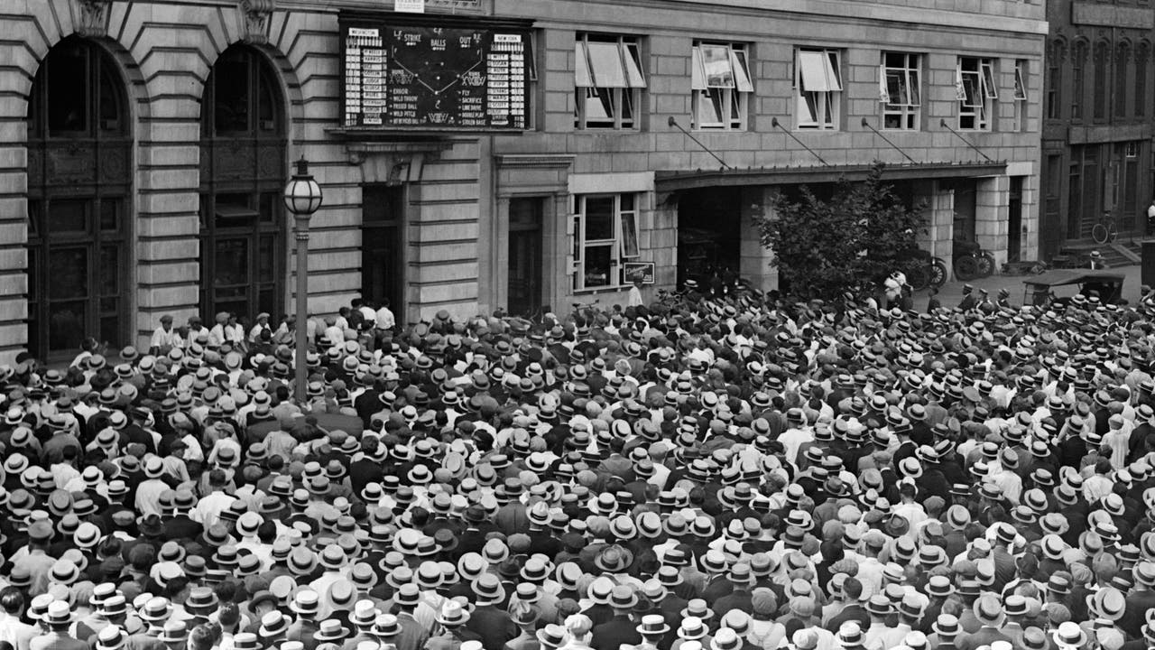 Zahlreiche Menschen betrachten die Ergebnisanzeige für ein Baseballspiel vor dem Haus der Zeitung »Washington Star« in Washington, DC, im August 1924.