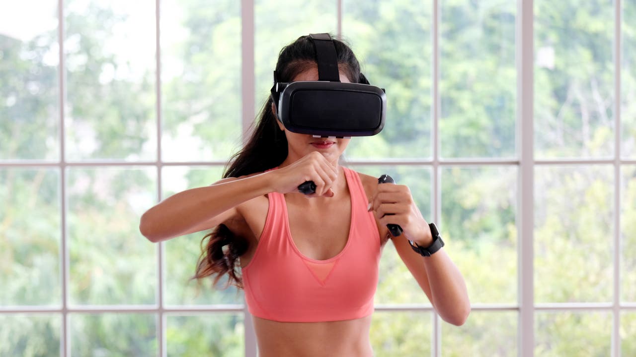 Junge Frau mit VR-Brille beim virtuellen Boxtraining