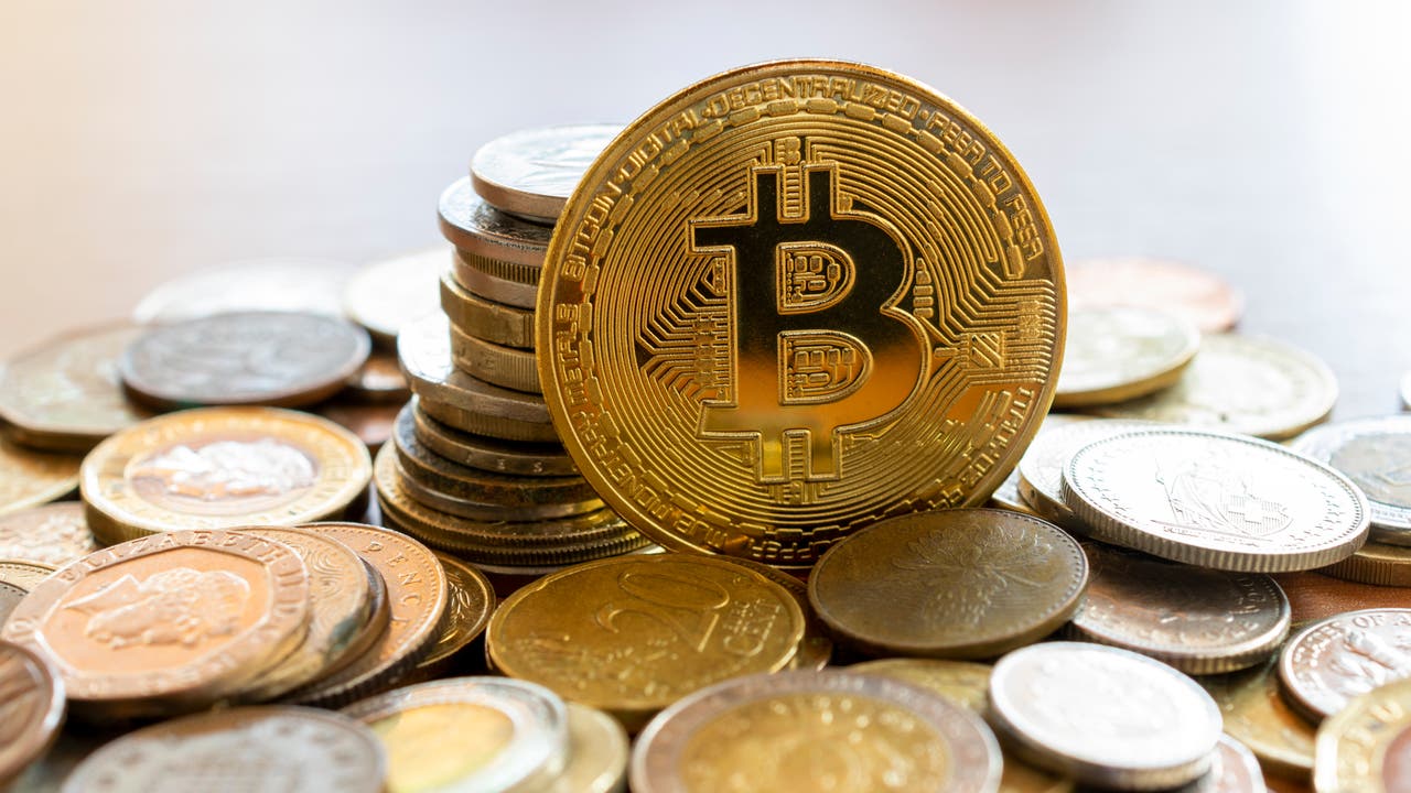 Ein Bitcoin liegt auf einem Haufen anderer Münzen