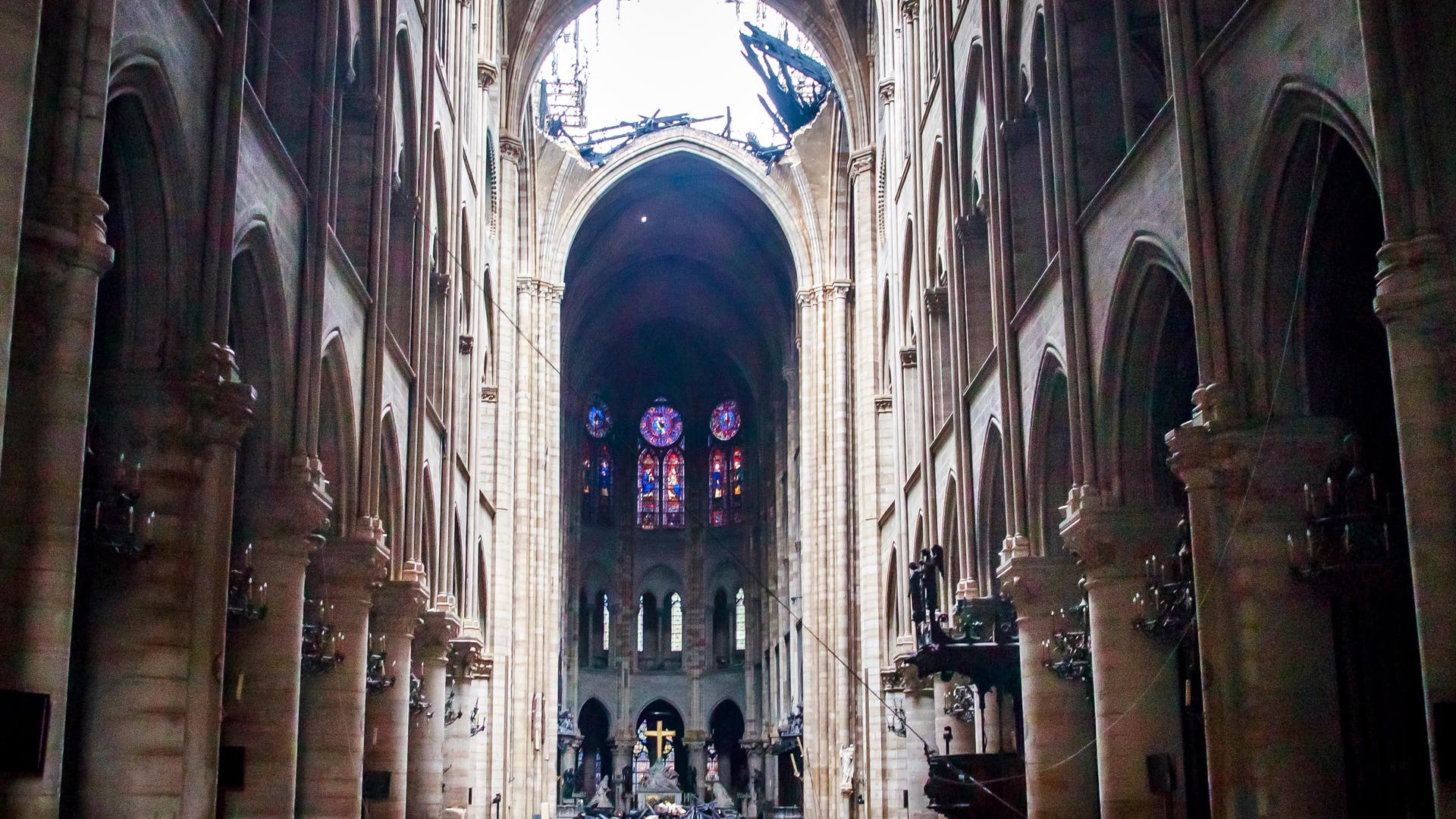 Nach dem Brand in Notre-Dame de Paris liegen im Chorhaus verbrannte Dachbalken, das Dach ist offen.