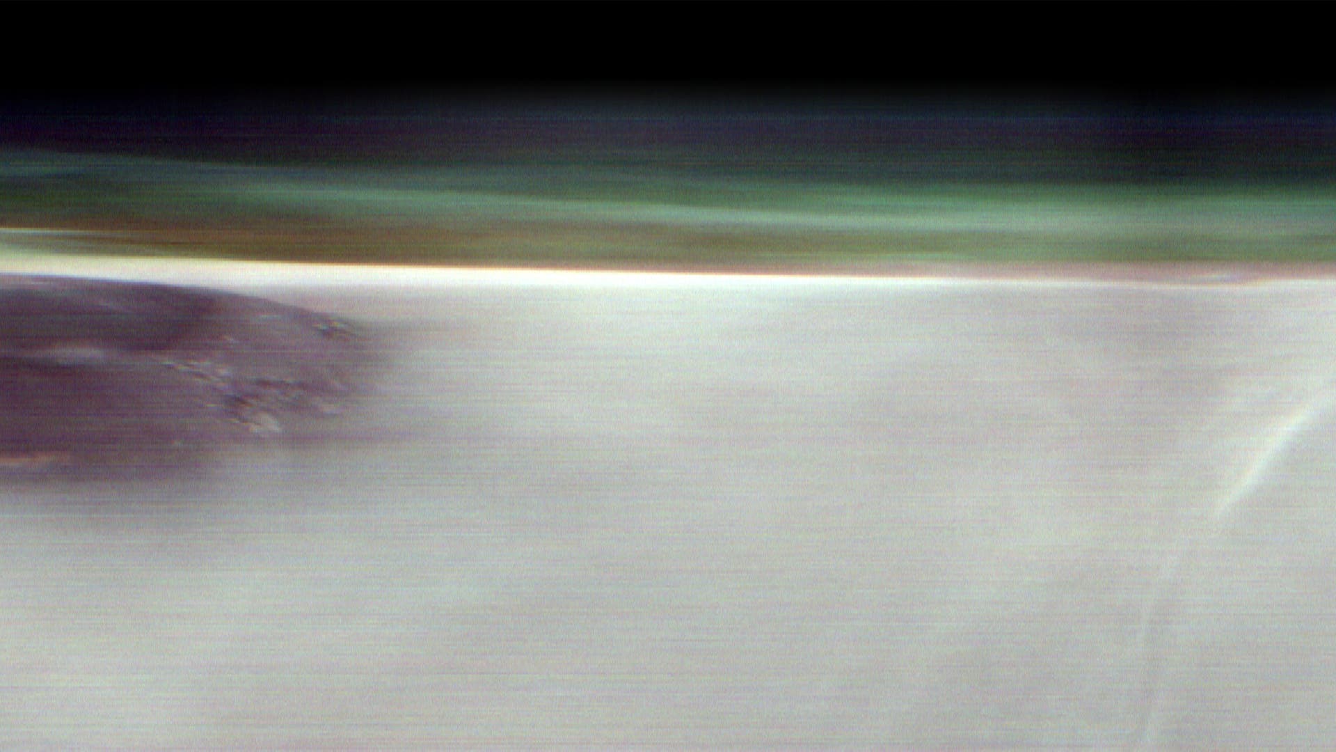 Aufnahme im Panorama-Format: ein dunkler Fleck ist die Gipfelregion des rund 20 Kilometer hohen Marsvulkans Arsia Mons, der sich in der Region Tharsis nahe dem Äquator des Roten Planeten befindet. Er überragt die ihn umgebenden dünnen Wolken aus Eiskristallen, die sich als diffuse hellere Partie im Rest des Bildes darstellen.