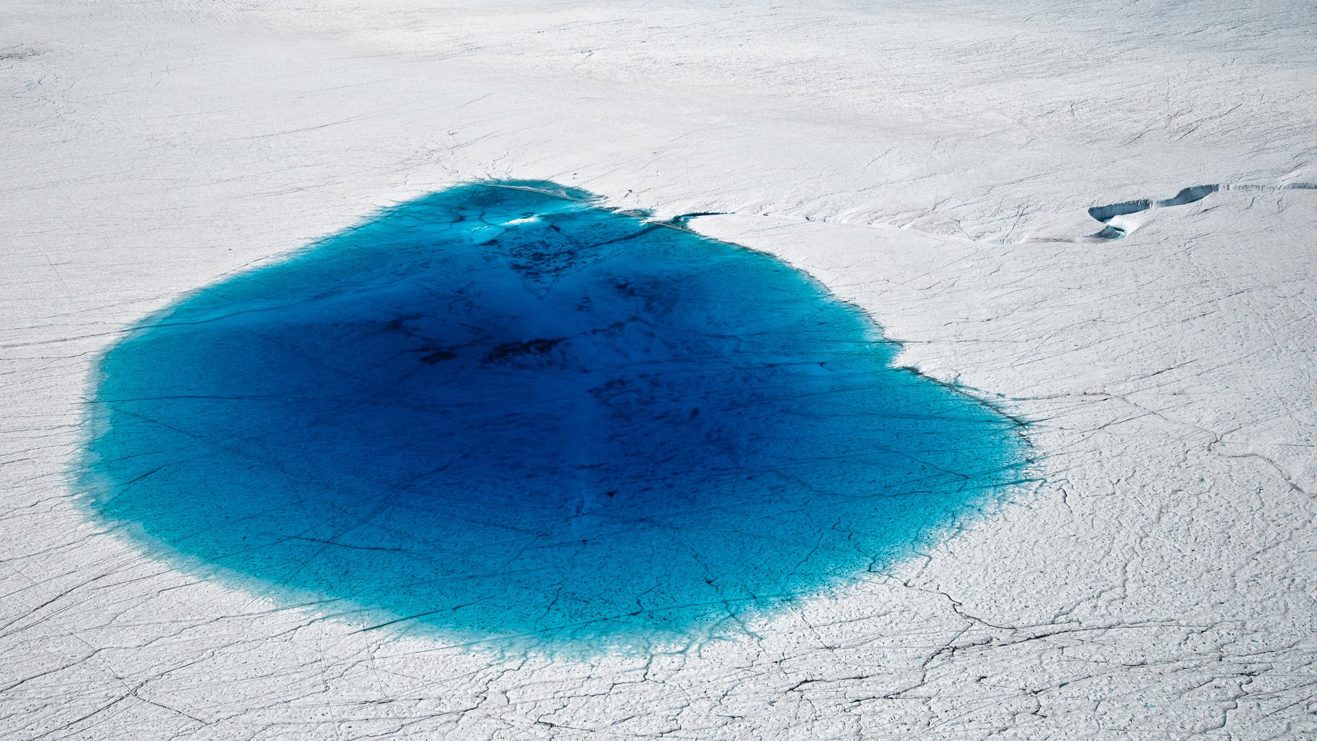 ein tiefblauer Gletschersee erstreckt sich auf einem Gletscher 