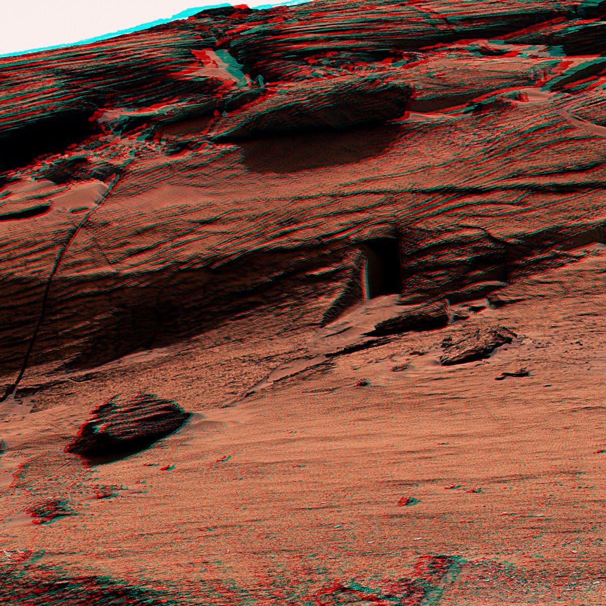 Das schwarze Rechteck sieht aus wie ein Eingang im Fels des Mars, ist aber nur eine natürliche Öffnung. Der Rover Curiosity hat sie fotografiert. 