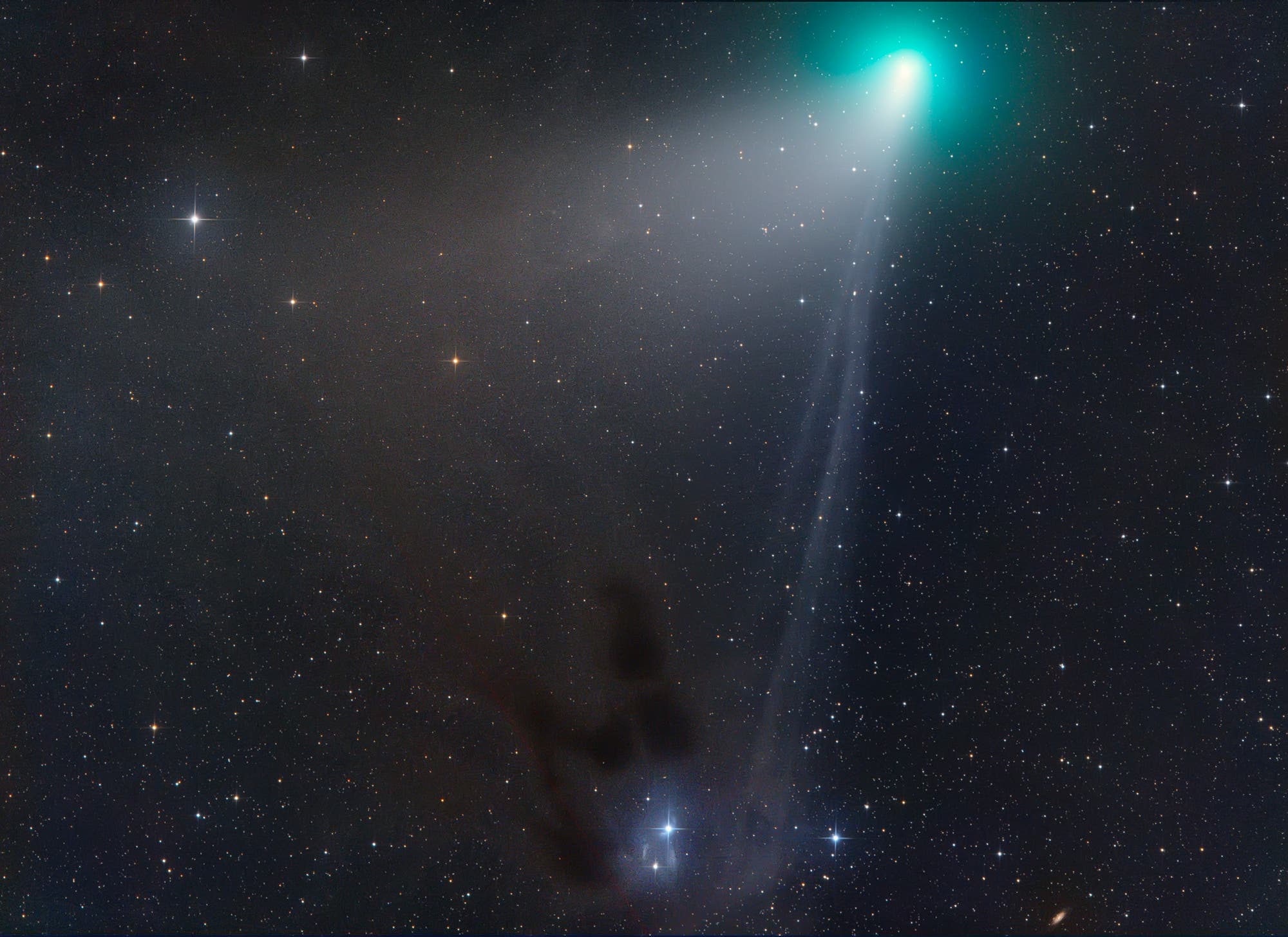 En el fondo del cielo nocturno, se debe reconocer una semilla de cometa que se baña verde y una gran cola de polvo y un estrecho Plaschmashwehr. Una niebla de gas lejana brilla debajo.