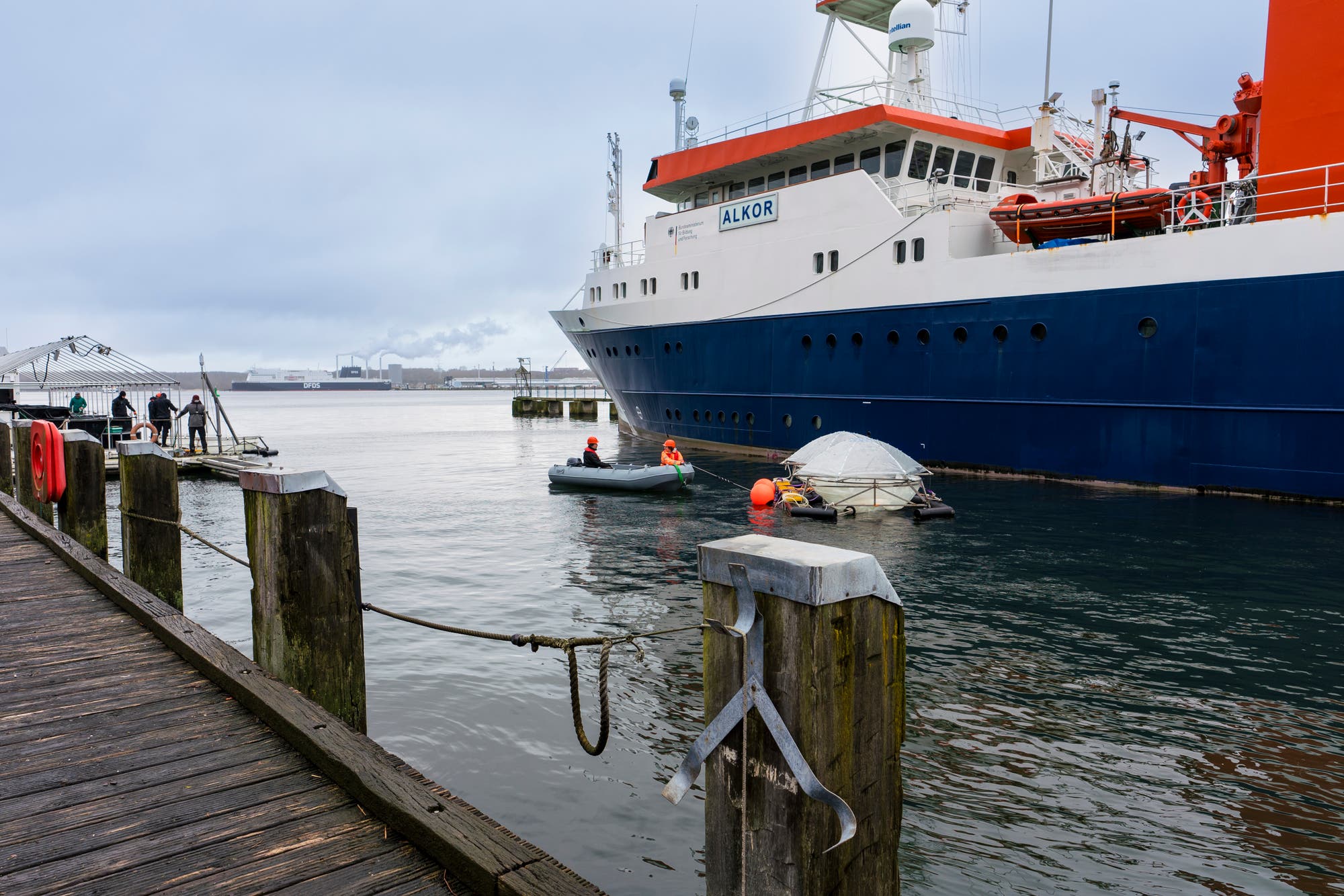 Mit einem Schlauchboot werden die Mesokosmen vom Forschungsschiff zur schwimmenden Plattform gebracht