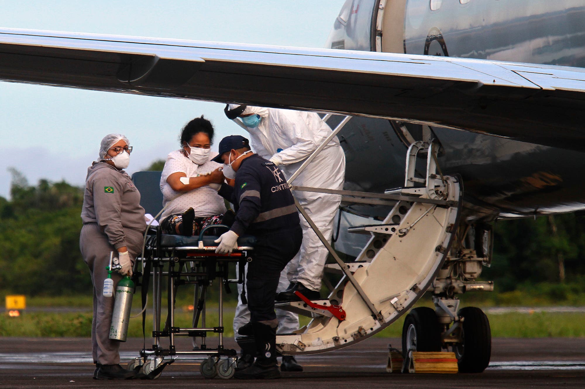Mitarbeiter des Gesundheitswesens und des Militärs bereiten sich am Flughafen Ponta Pelada in Manaus darauf vor, eine Covid-19-Patientin in ein Flugzeug der Luftwaffe zu verfrachten, um sie in ein Krankenhaus außerhalb der Stadt zu bringen.