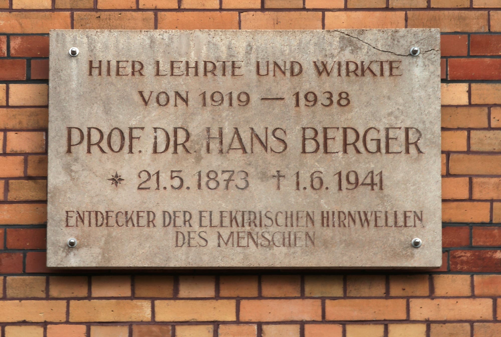 Gedenktafel mit Lebensdaten und Lehrzeit Hans Bergers an einer Klinkerwand an der Fassade der Klinik für Psychiatrie und Psychotherapie des Universitätsklinikums Jena.