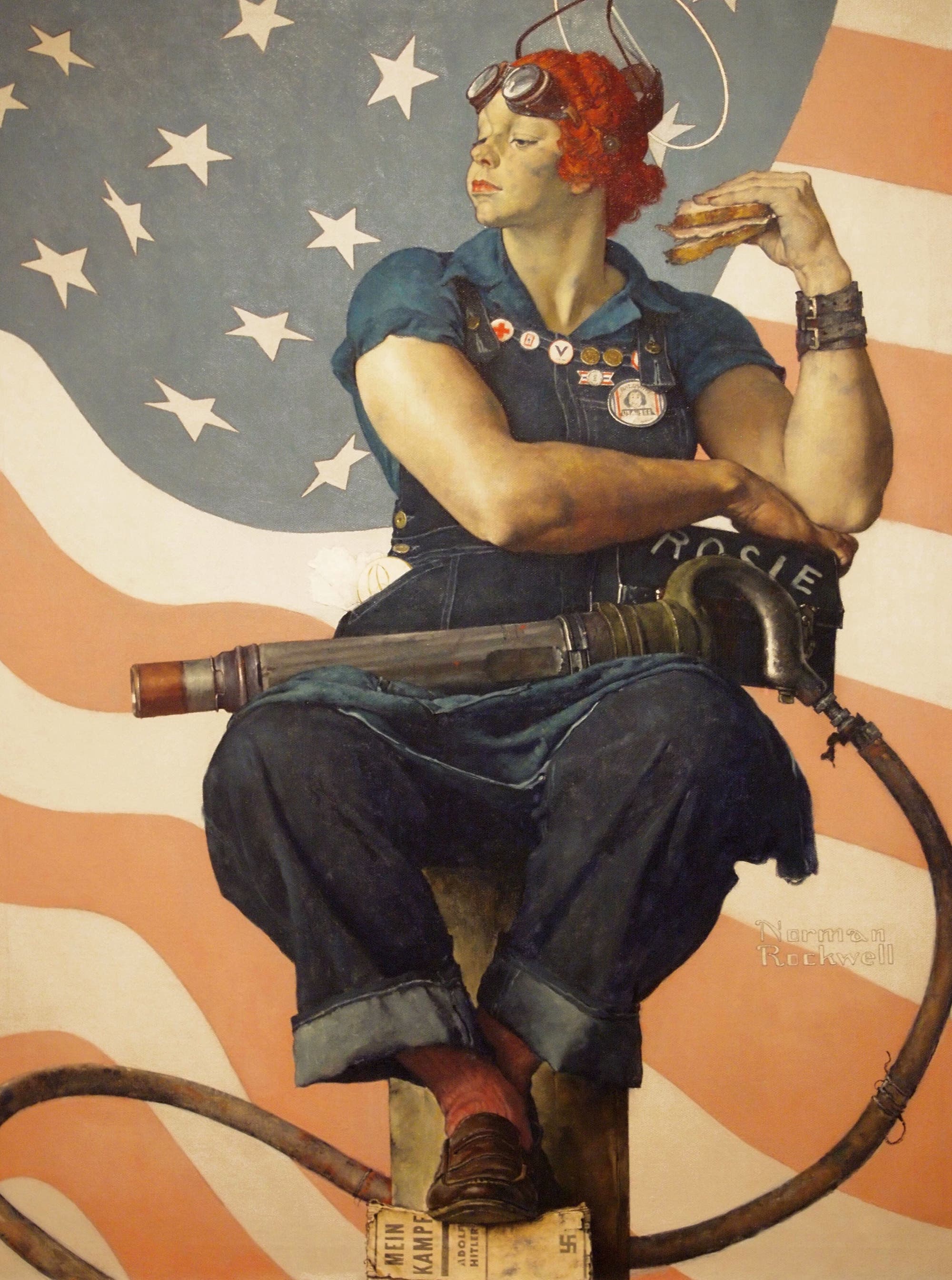Eine Frau in blauer Arbeitskleidung sitzt auf einem Balken vor einer amerikanischen Flagge. Sie trägt eine Schutzbrille auf dem Kopf und hält ein Sandwich in der rechten Hand. Auf ihrem Overall sind mehrere Abzeichen zu sehen, darunter eines mit der Aufschrift "Rosie". Ein großer Schraubenschlüssel ruht auf ihrem Schoß. Unter ihrem Fuß liegt ein Buch mit der Aufschrift "Mein Kampf". Das Bild vermittelt Stärke und Patriotismus. Im Hintergrund sind rote und weiße Streifen sowie weiße Sterne auf blauem Grund zu sehen.