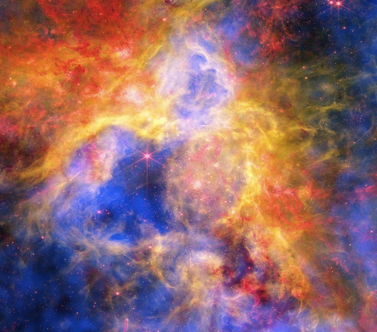 Eine farbenfrohe astronomische Aufnahme eines Nebels im Weltraum. Die Abbildung zeigt leuchtende Wolken aus Gas und Staub in verschiedenen Farben, darunter Blau, Gelb und Rot. Im Hintergrund sind zahlreiche Sterne zu sehen, die als helle Punkte erscheinen. Die Farben und Formen der Nebelwolken erzeugen ein dynamisches und faszinierendes Muster. Eine farbenfrohe astronomische Aufnahme eines Nebels im Weltraum. Die Abbildung zeigt leuchtende Wolken aus Gas und Staub in verschiedenen Farben, darunter Blau, Gelb und Rot. Im Hintergrund sind zahlreiche Sterne zu sehen, die als helle Punkte erscheinen. Die Farben und Formen der Nebelwolken erzeugen ein dynamisches und faszinierendes Muster.