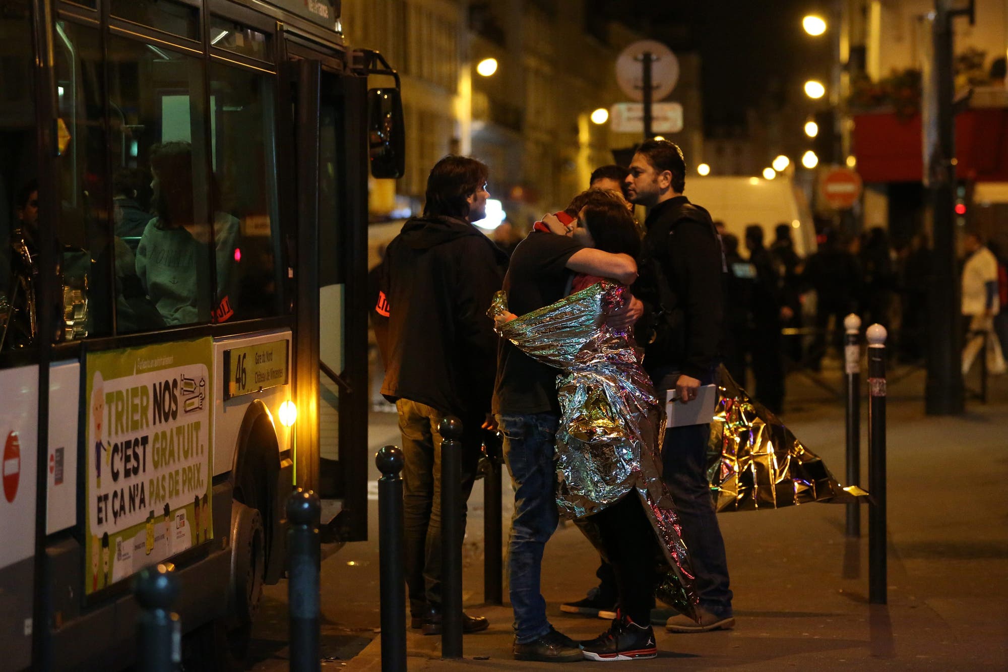 Zwei Menschen umarmen sich tröstend, mutmaßlich Besucher des Konzerts des Pariser Musikclubs Bataclan, während dessen das Attentat stattfand.