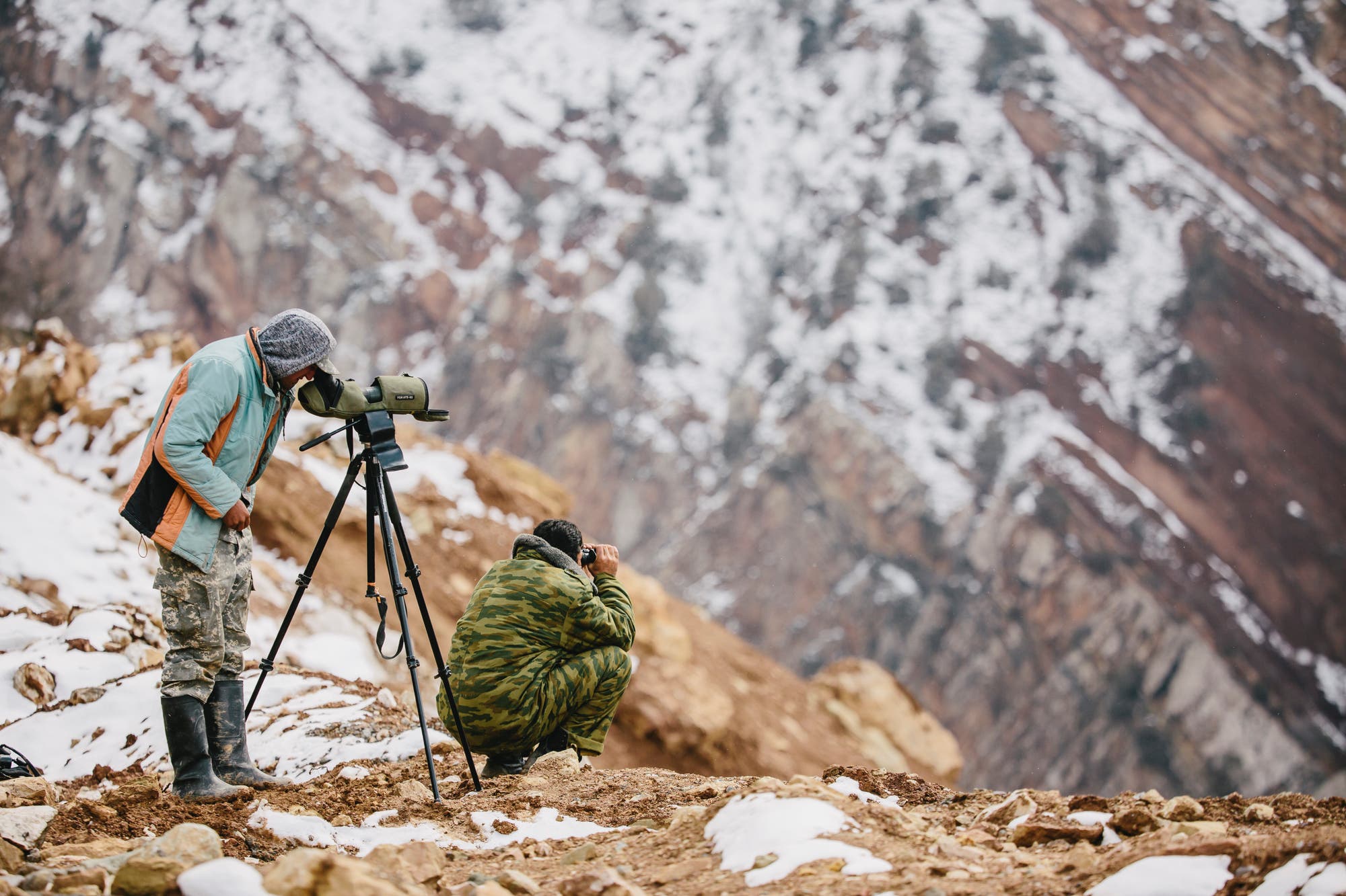 Zwei tadschikische Ranger suchen in einem der Jagdgebiete nach den Markhors, die gerne durch steile Felshänge steigen.