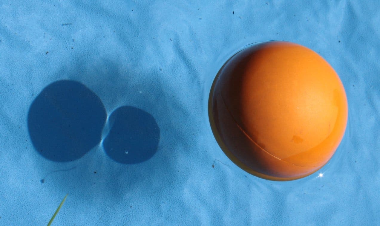 ein schwimmender Ball wirft einen großen, diffusen Schatten und darin zwei runde, die sich berühren
