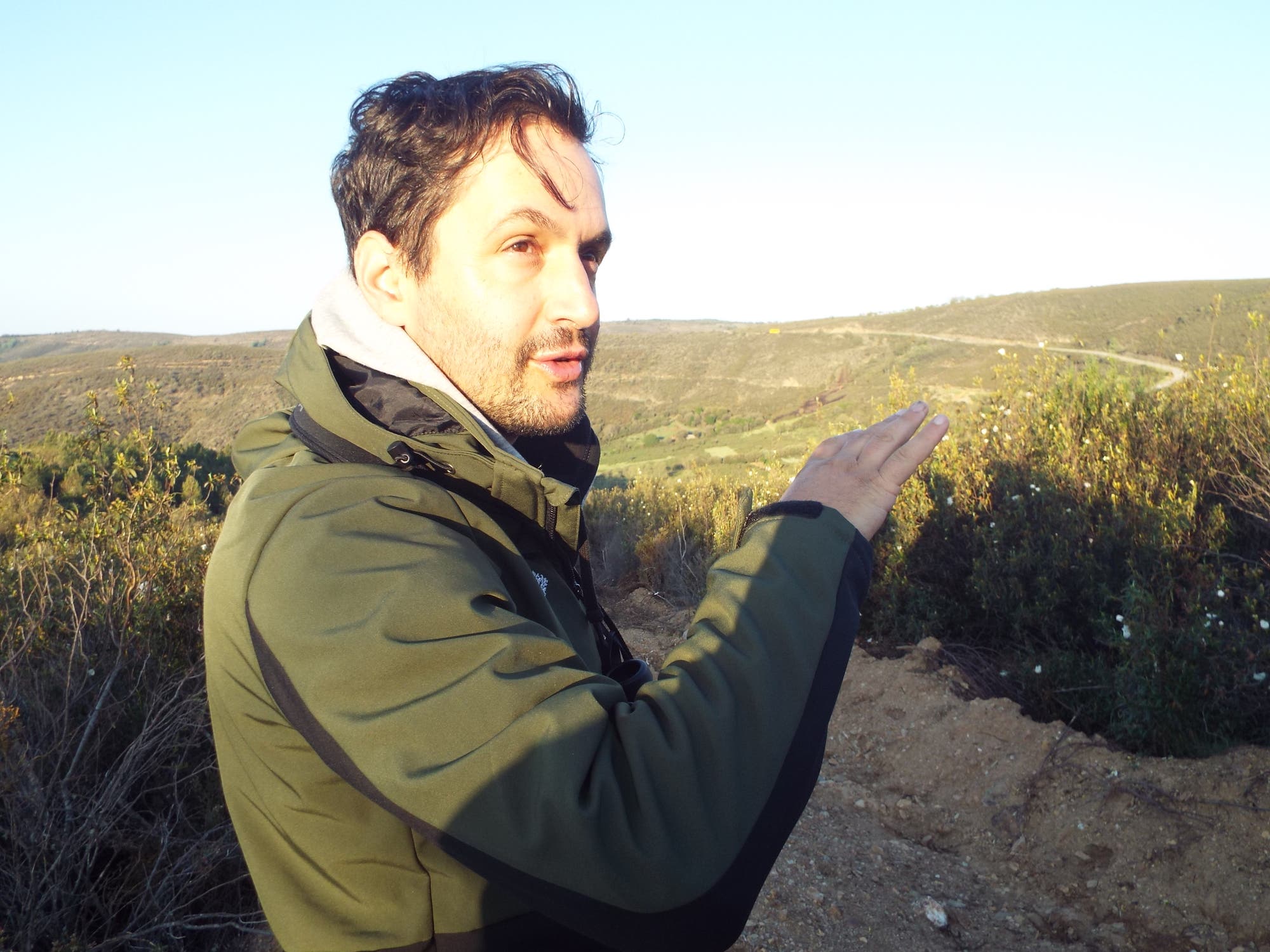 Petro Prata, der Teamleiter von Rewilding Portugal, zeigt auf die Landschaft vor ihm.