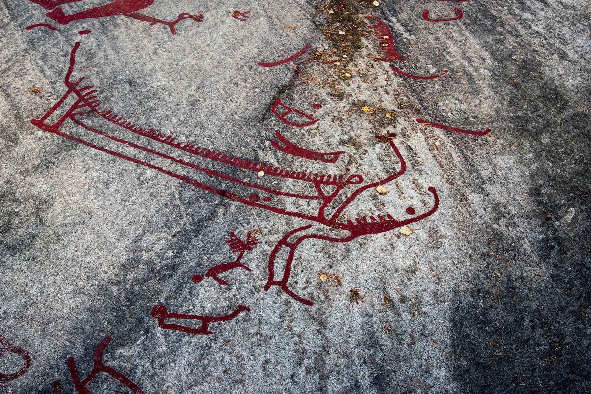 Mit roter Farbe nachgezogene Linienzeichnung eines Bronzezeitlichen Schiffs.