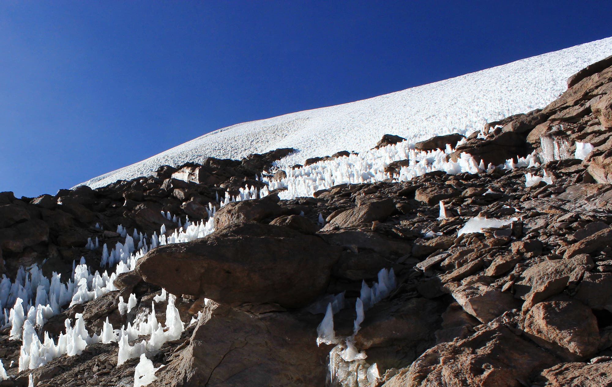Ein Feld aus Eisspitzen erstreckt sich über einen Berghang