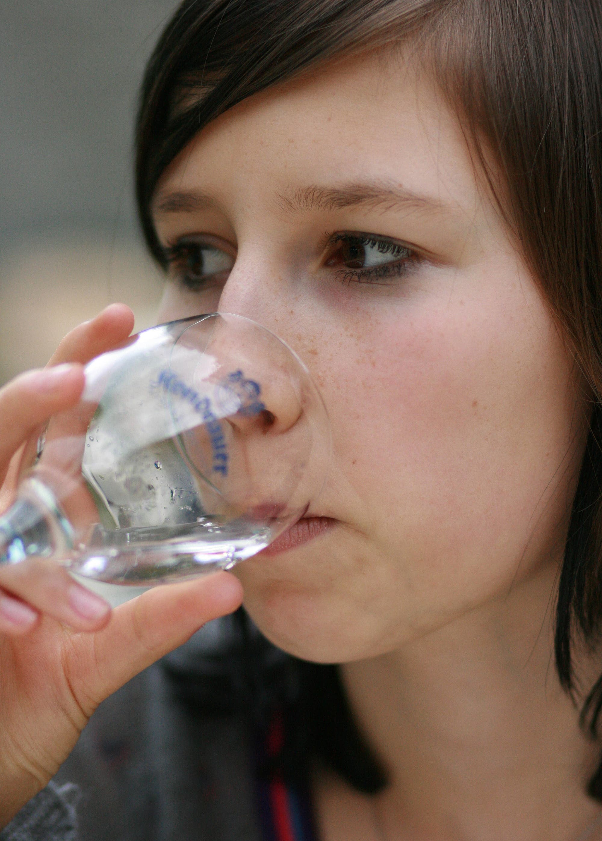 Frau trinkt aus einem Glas Wasser