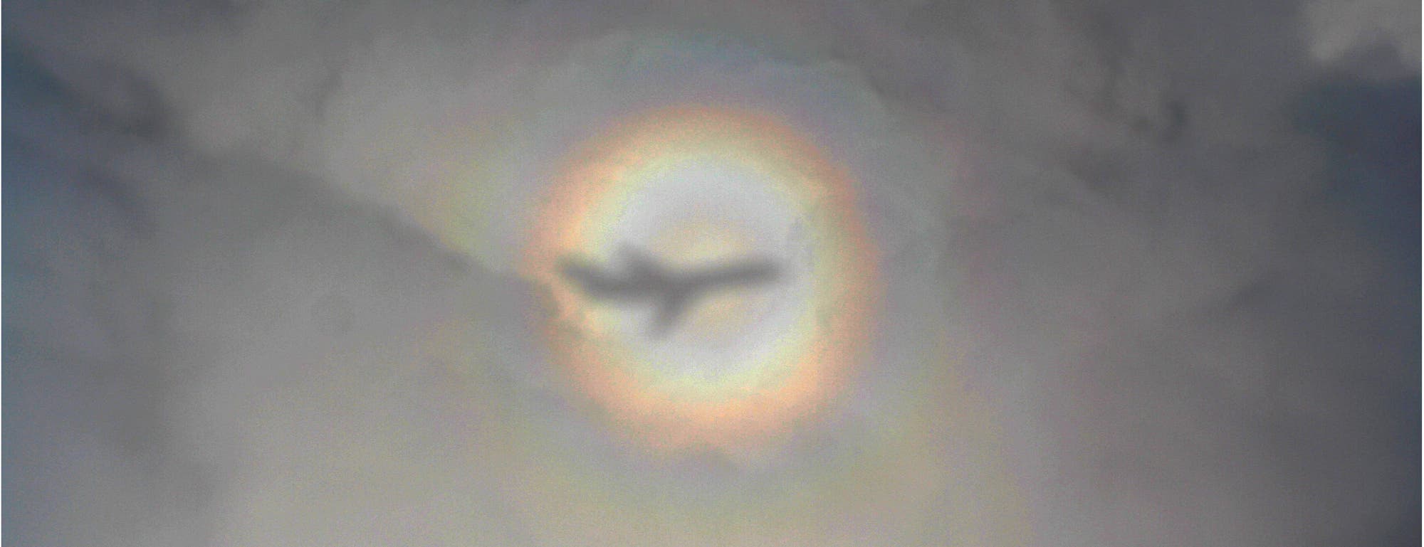 Aureole – Leuchterscheinung am Himmel, durch die ein Flugzeug fliegt