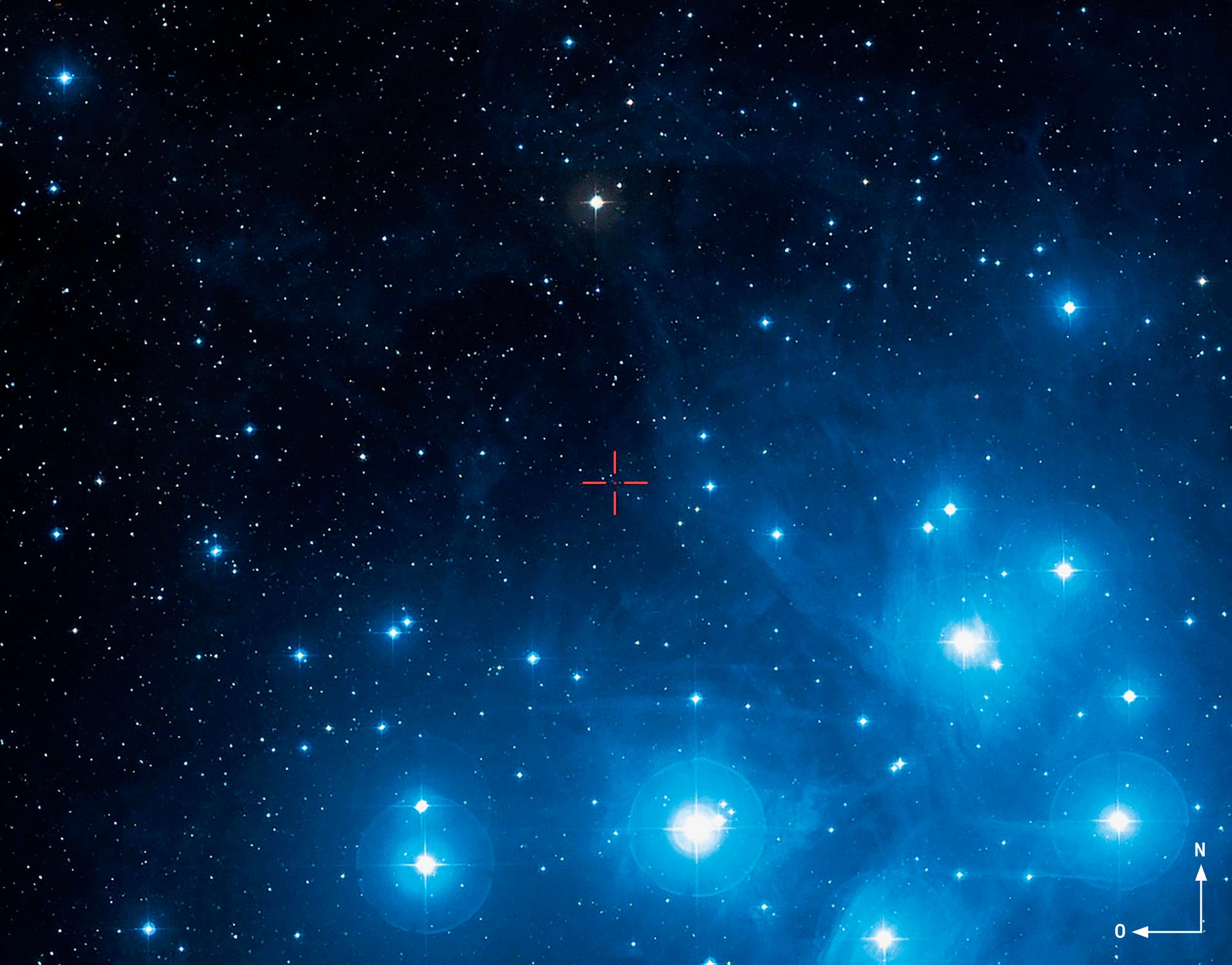 Eine astronomische Aufnahme zeigt einen Sternenhaufen vor einem dunklen Hintergrund. Mehrere helle Sterne sind sichtbar, umgeben von einem bläulichen Schimmer, der auf interstellaren Staub hindeutet. Im oberen linken Eck ist der Text "DSS2 color" zu sehen. Die Aufnahme vermittelt die Weite und Schönheit des Weltraums und hebt die Leuchtkraft der Sterne hervor.