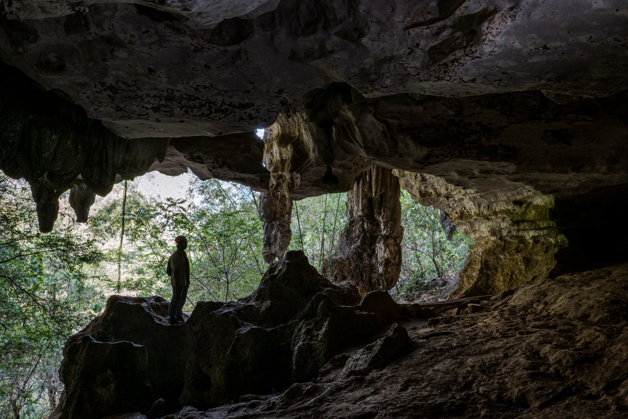 Ein Archäologe der staatlichen Kulturbehörde steht am Eingang einer Höhle des Karstbergs Bulu’ Sipong 4.