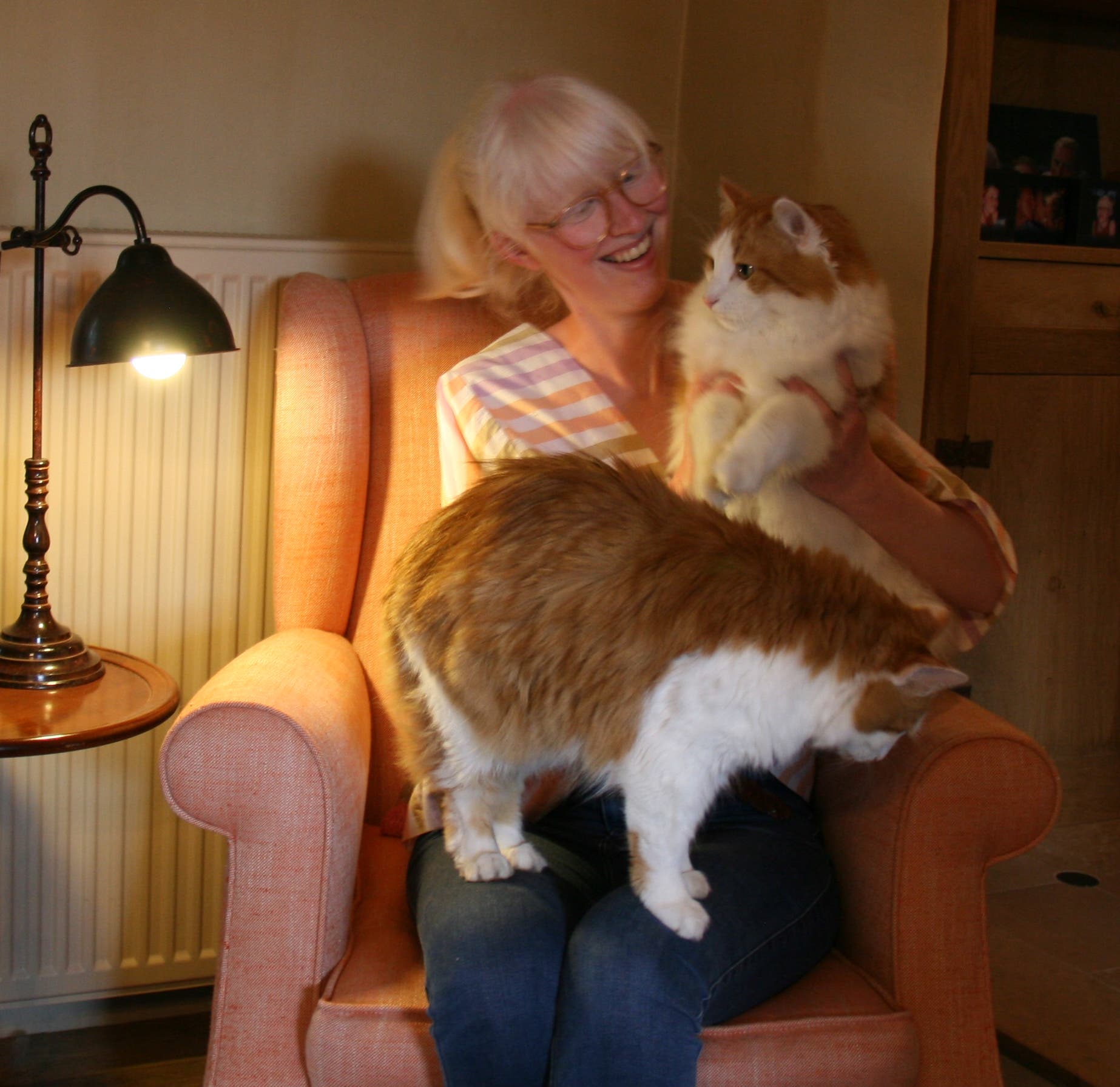 Morgane Van Belle in einem Sessel mit ihren zwei Katzen