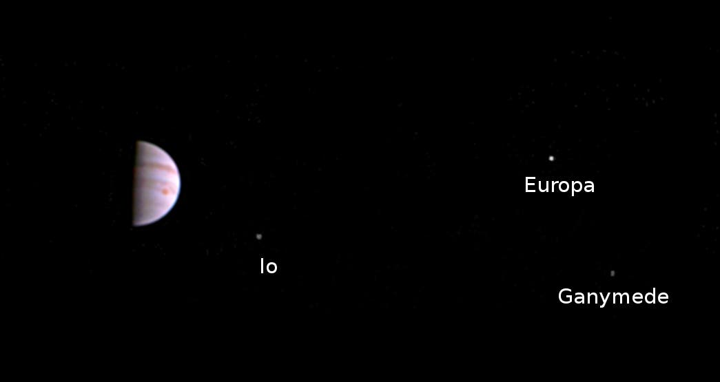 Junos erstes Bild aus dem Jupiterorbit mit Jupiter in Halbphase und drei Monden