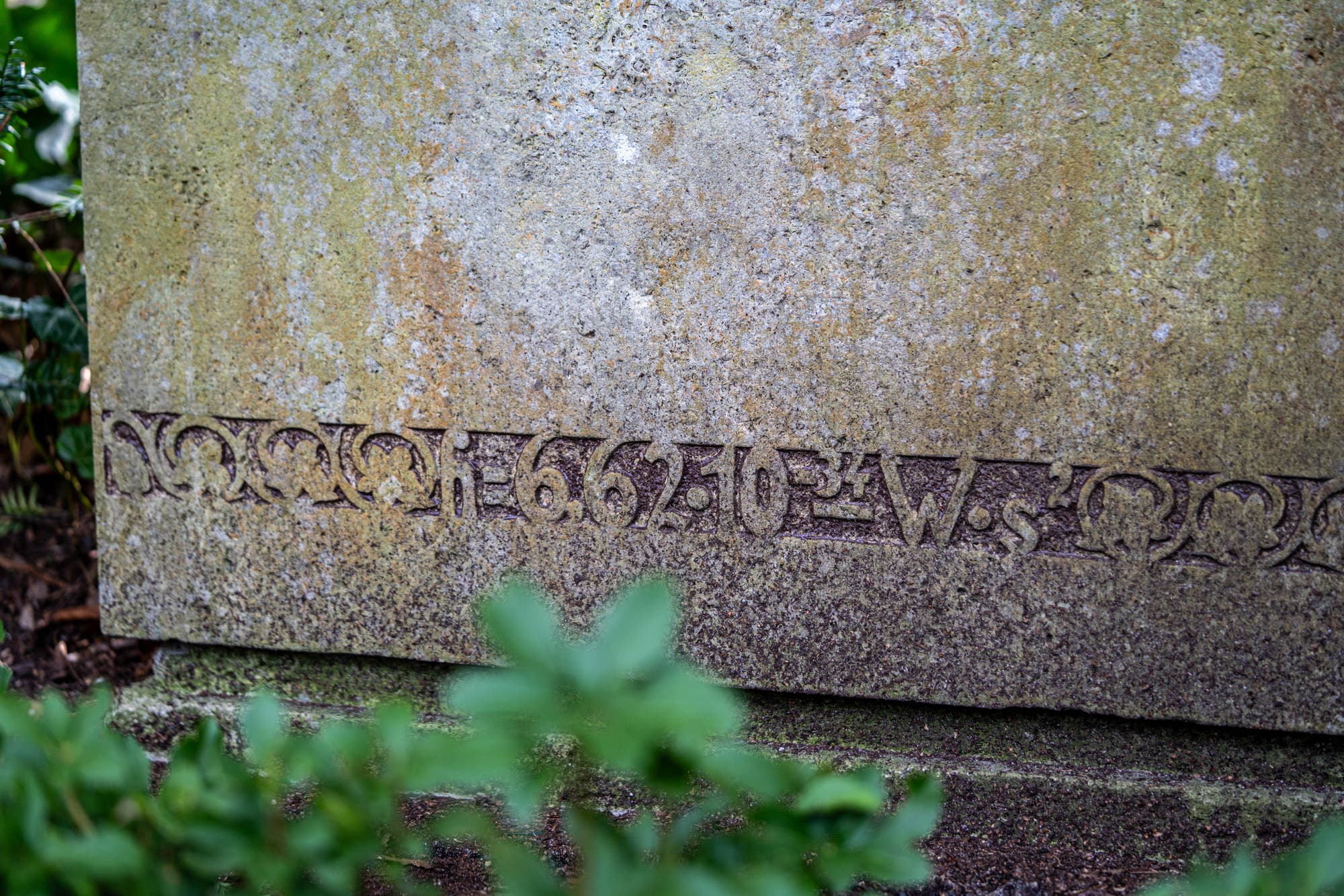 Eine verwitterte Steinplatte mit eingravierten Zahlen und Buchstaben. Es ist der Wert der Planck-Konstante h.