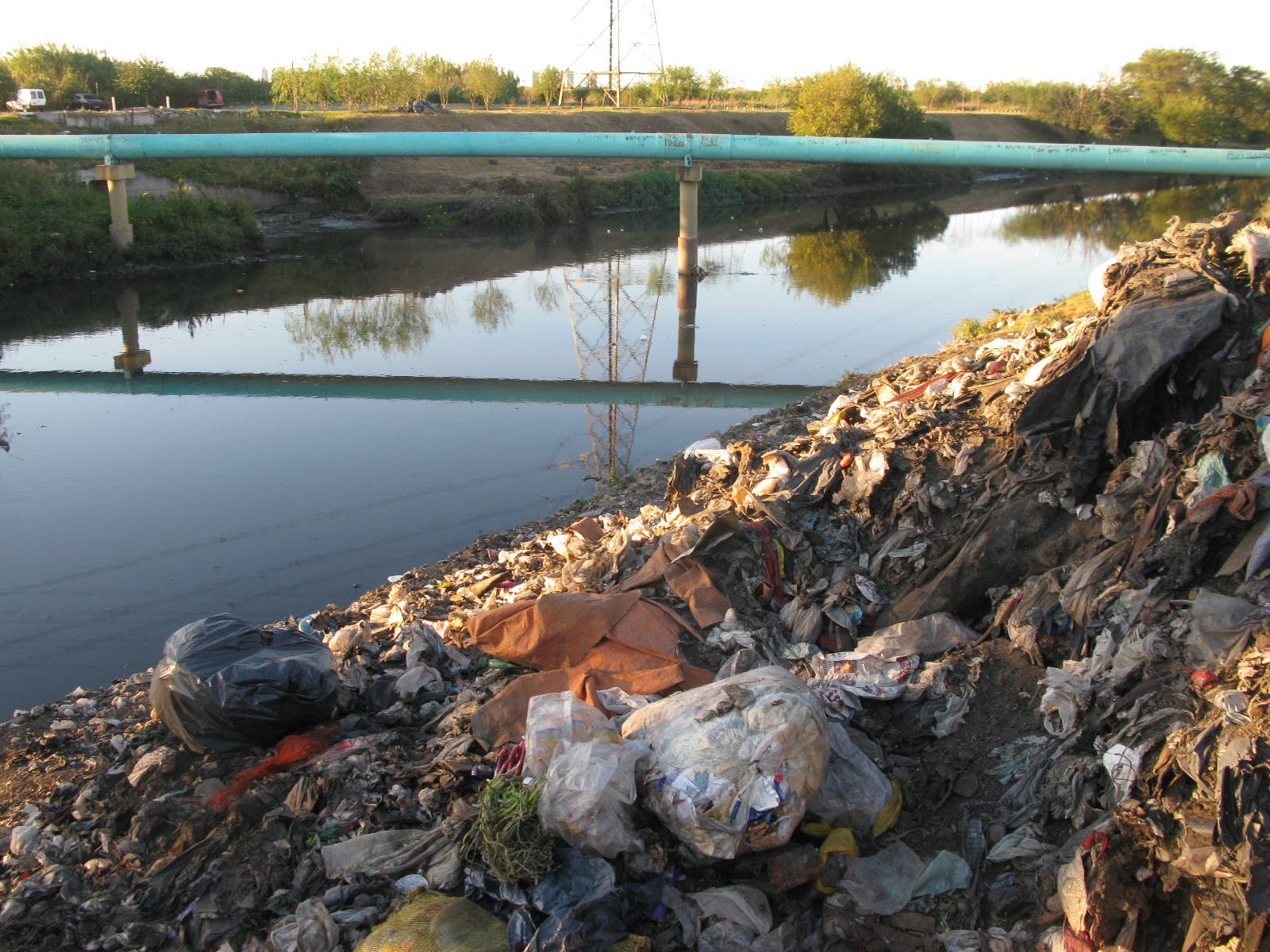 Ein mit Müll verunstaltetes Flussufer