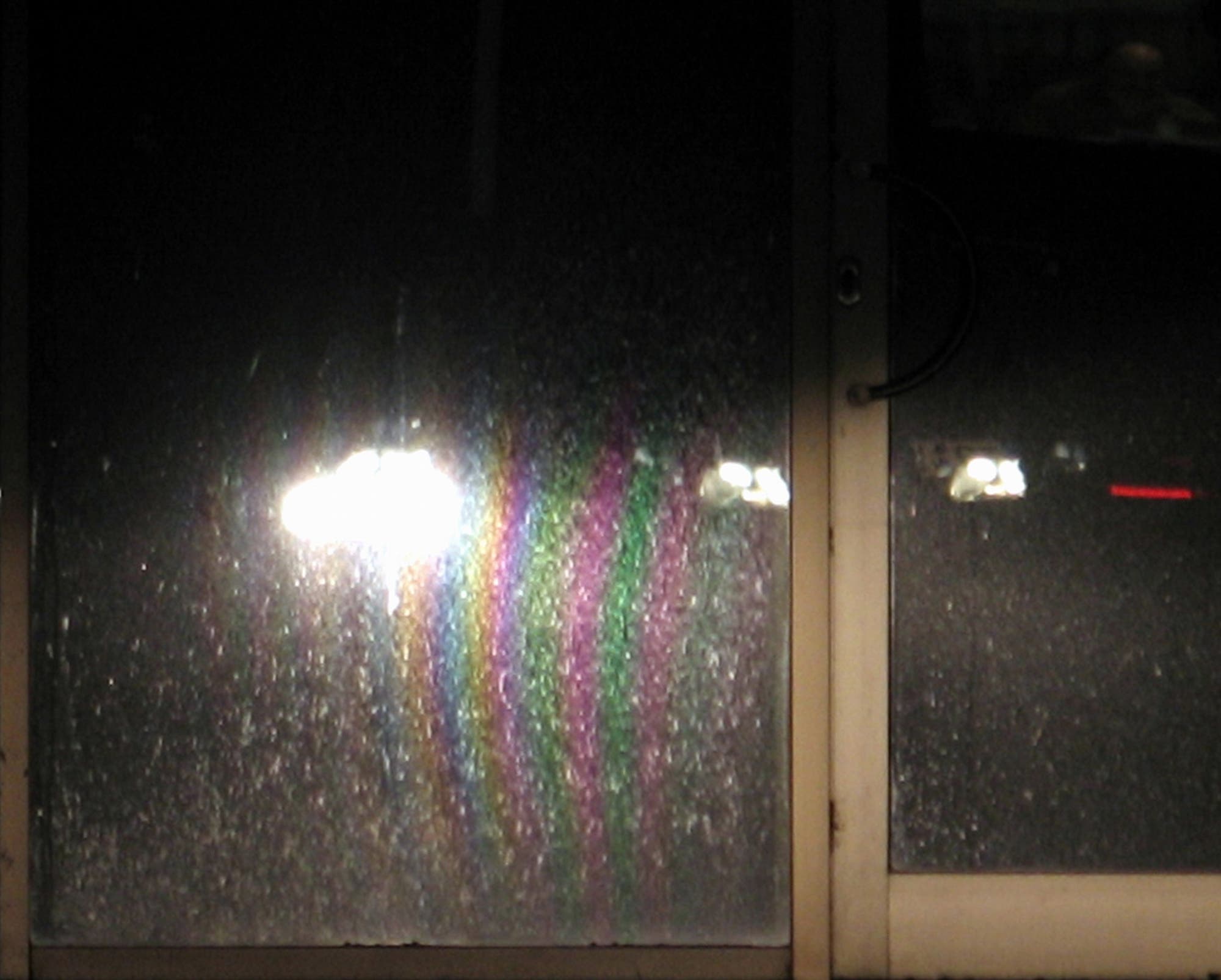 Ein Auto erzeugt queteletsche Streifen auf einem verschmutzten Schaufenster.