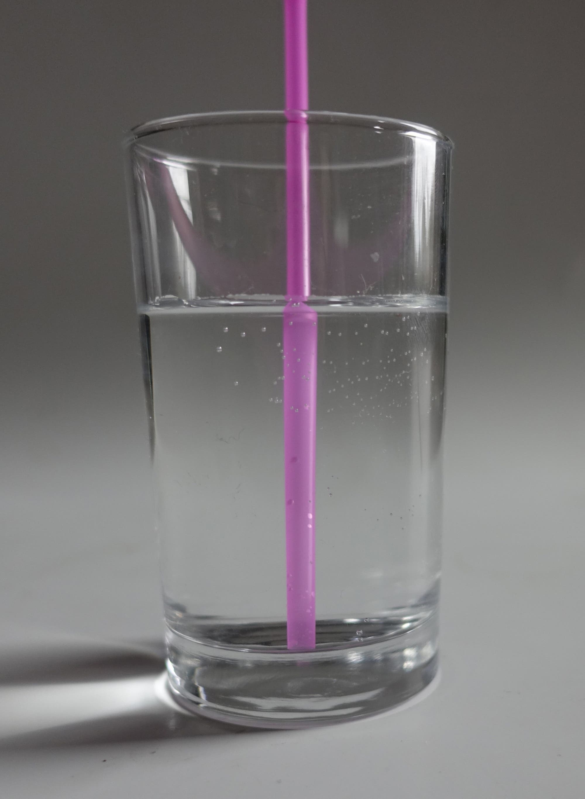 Glas Wasser mit Trinkhalm