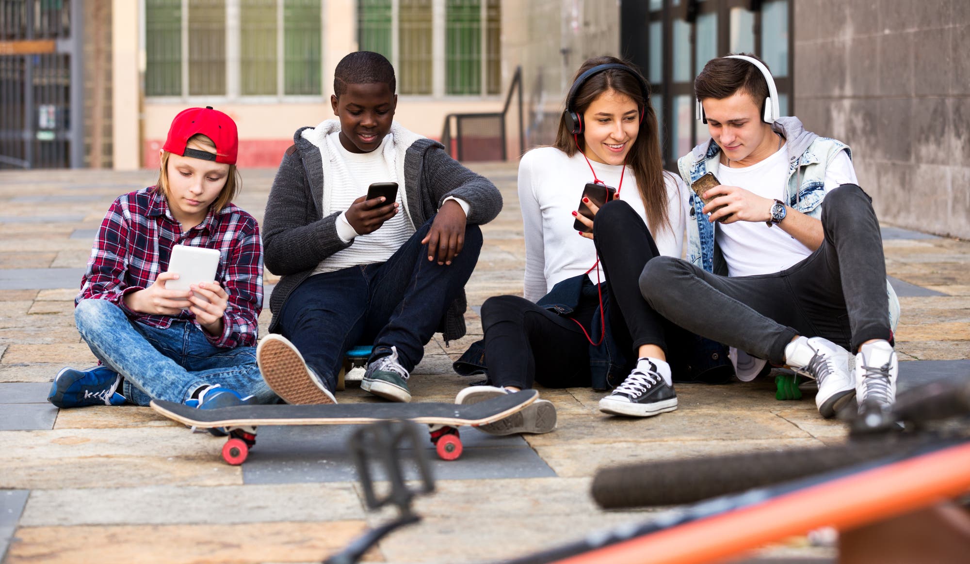 Glückliche Teenager verbringen ihre Zeit, um gemeinsam auf das Smartphone zu schauen