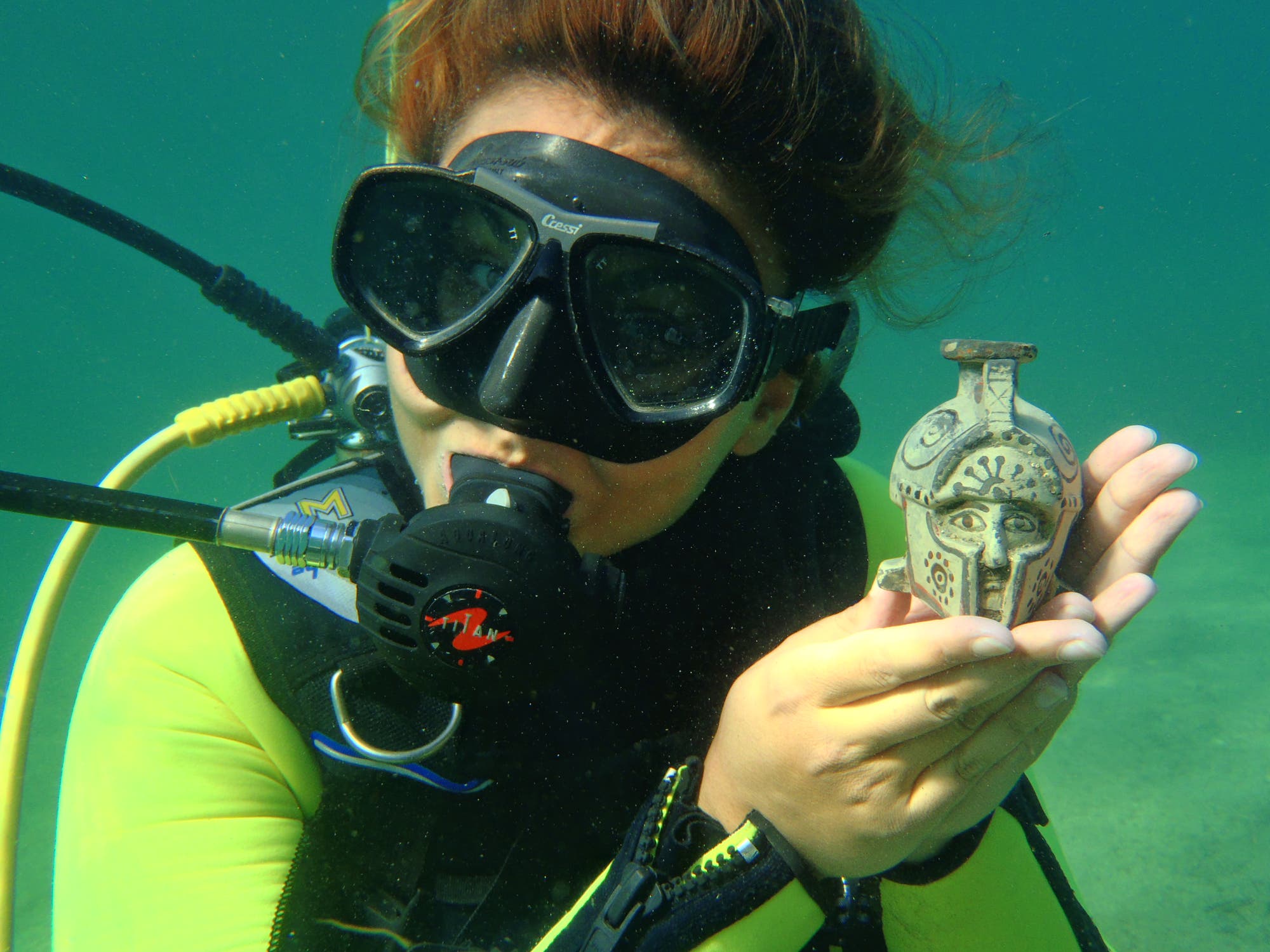 Unterwasserarchäologin hält Fund in der Hand
