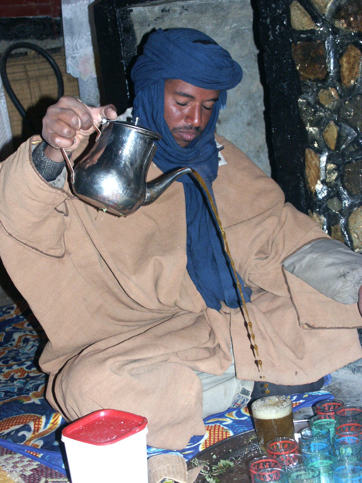 Bei einer Teezeremonie wird Tee aus einer Kanne in hohem Bogen in Gläser gegossen
