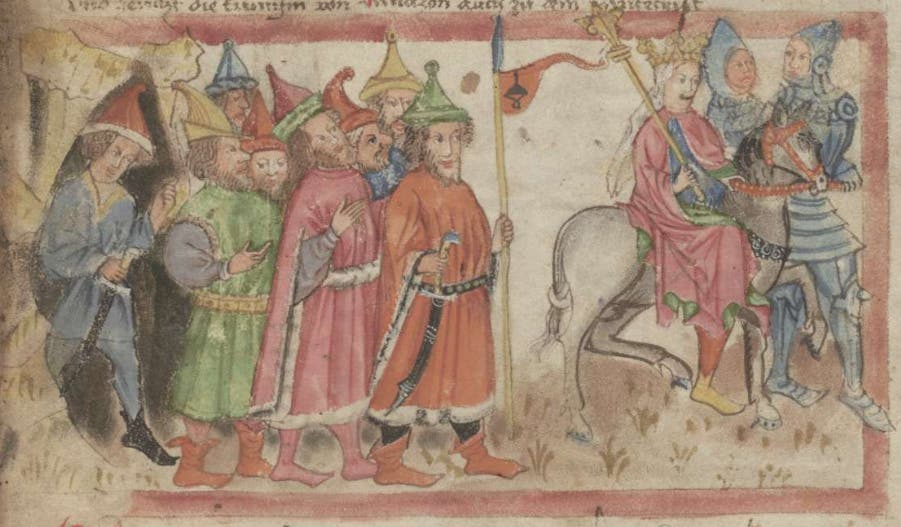 Eine mittelalterliche Illustration zeigt eine Gruppe von Männern in bunten Gewändern und spitzen Hüten, die eine Prozession bilden. Sie stehen links im Bild. Rechts reitet eine Person in einem rosa Gewand auf einem Pferd, begleitet von einem Ritter in Rüstung. Die Szene ist reich an Details und Farben, die typisch für mittelalterliche Kunst sind. Im Hintergrund sind keine spezifischen Landschaftsmerkmale erkennbar.