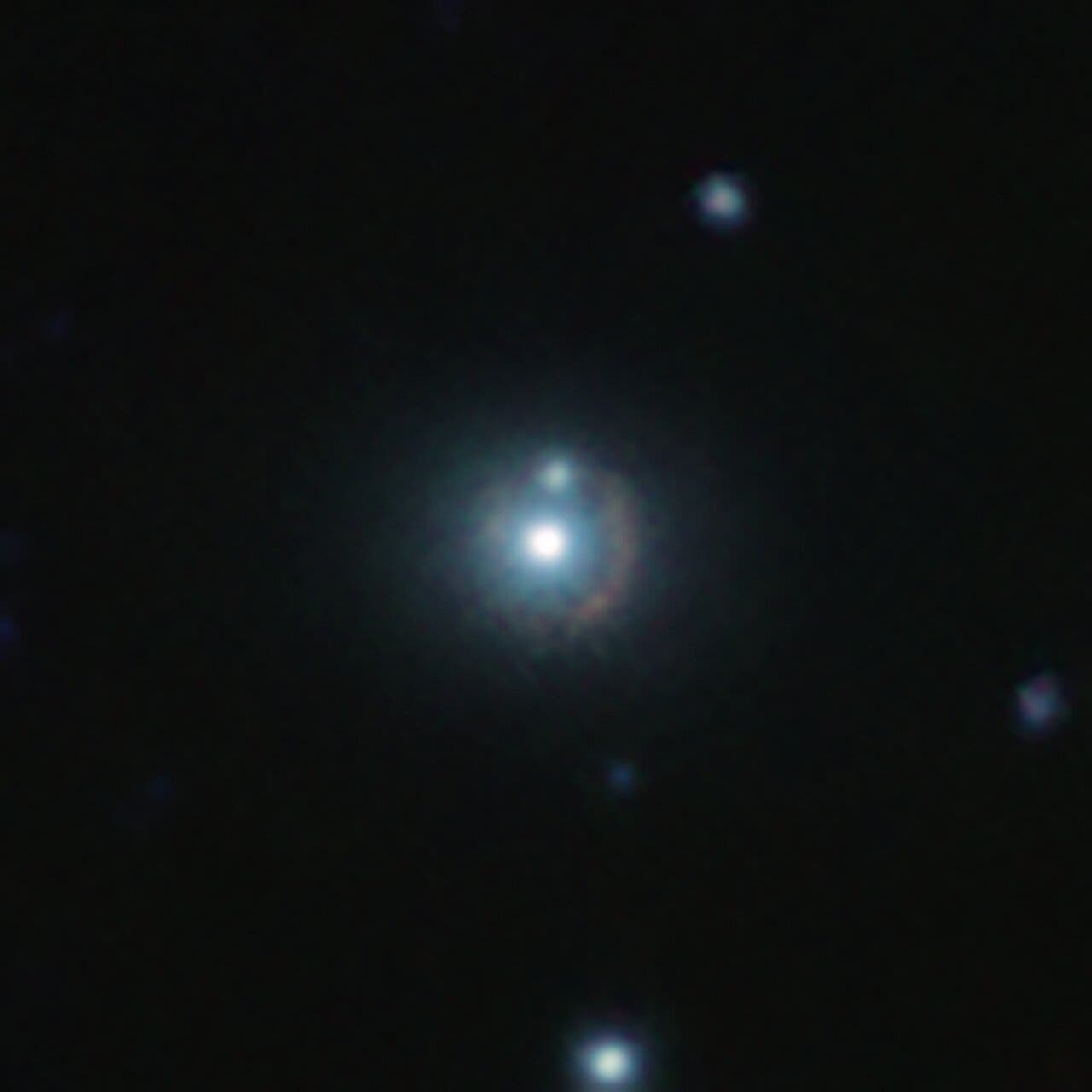Die Galaxie 9io9 im nahinfraroten Bereich als rötlicher Bogen
