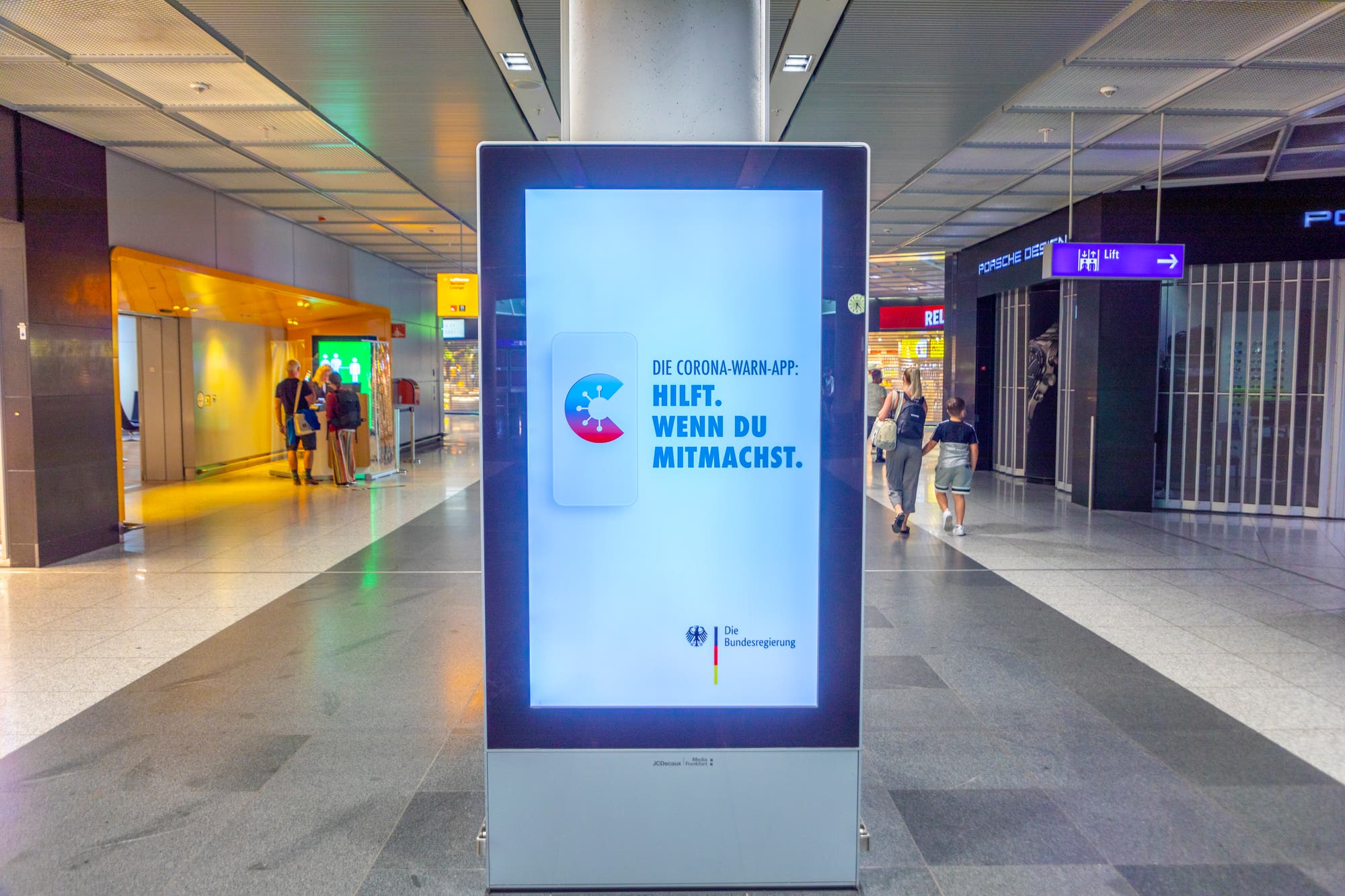 Mit der Corona-Warn-App, hier auf einem Screen in Frankfurt beworben, verbanden sich große Hoffnungen. Doch sie trägt kaum dazu bei, die Pandemie einzudämmen.