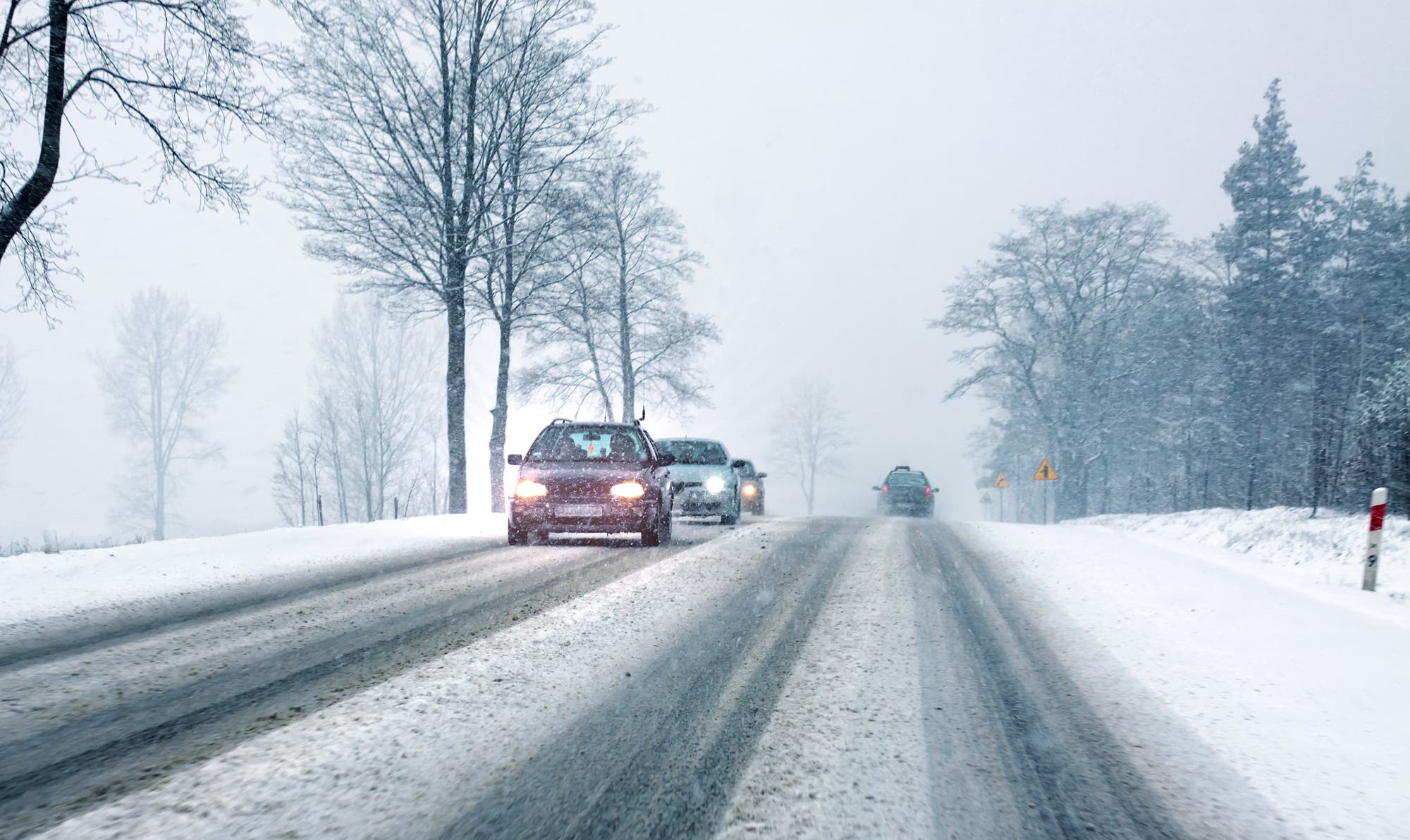 Autos fahren auf einer verschneiten Landstraße