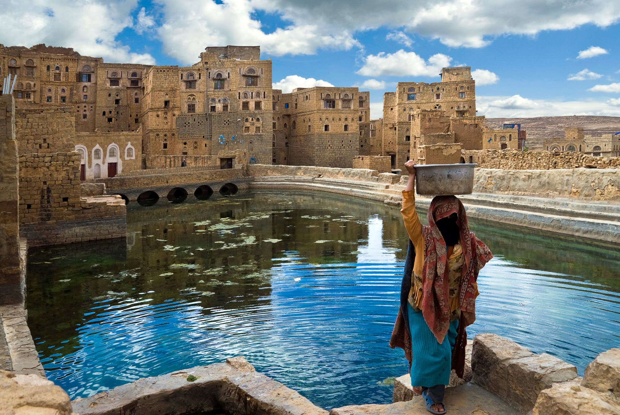 Jemenitin holt Wasser an einem öffentlichen Basin