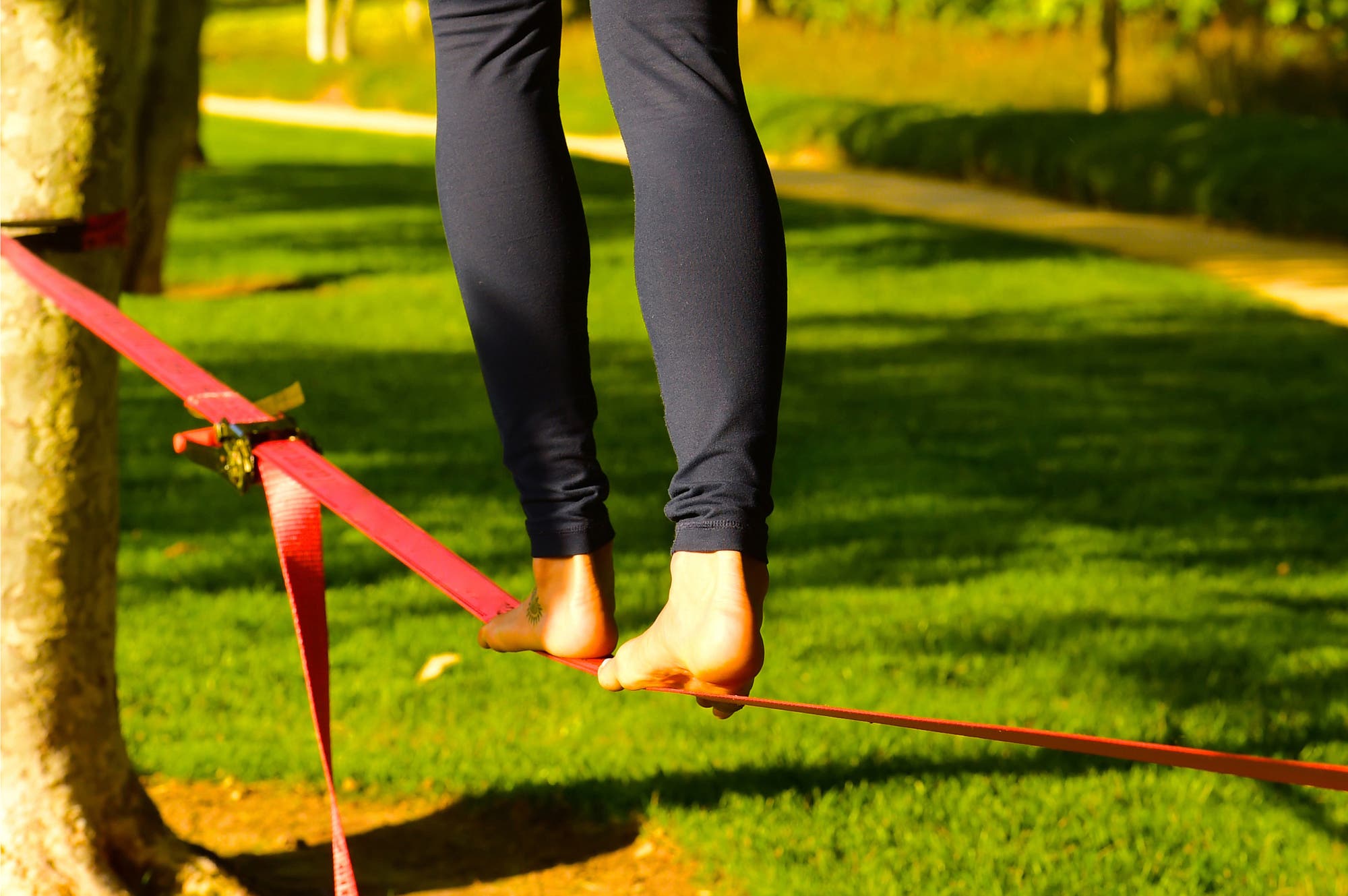 Nackte Füße balancieren auf einem Seil im Park