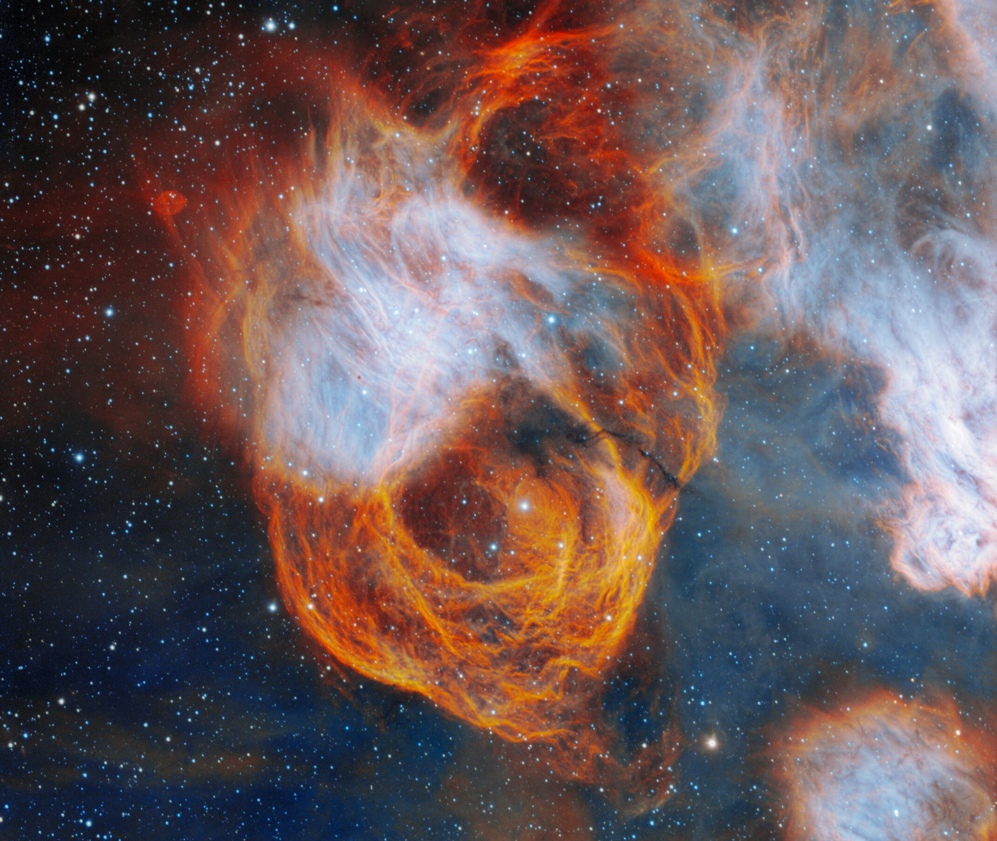 Ein Bild des kosmischen Nebels NGC 2040 in der Großen Magellanschen Wolke, der in leuchtenden Orange- und Blautönen leuchtet. Hier entstehen zahlreiche massereiche Sterne, die den Spektralklassen O und B angehören.
