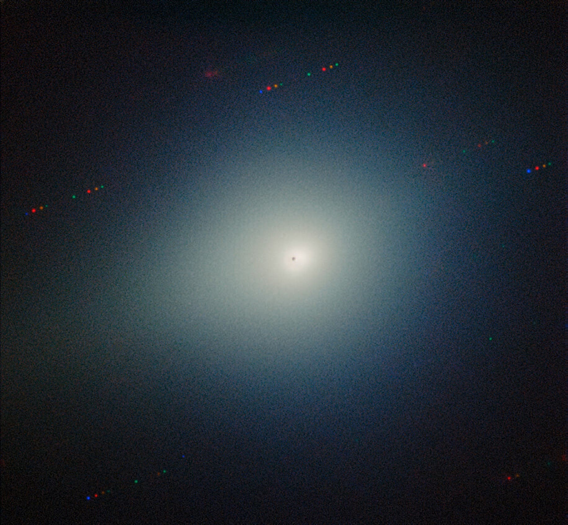 Das astronomisches Bild zeigt den Kometen 3I/ATLAS umgeben von einem hellen Schein, der Koma. Der Hintergrund ist dunkel, mit verstreuten Lichtpunkten, die Sterne darstellen.