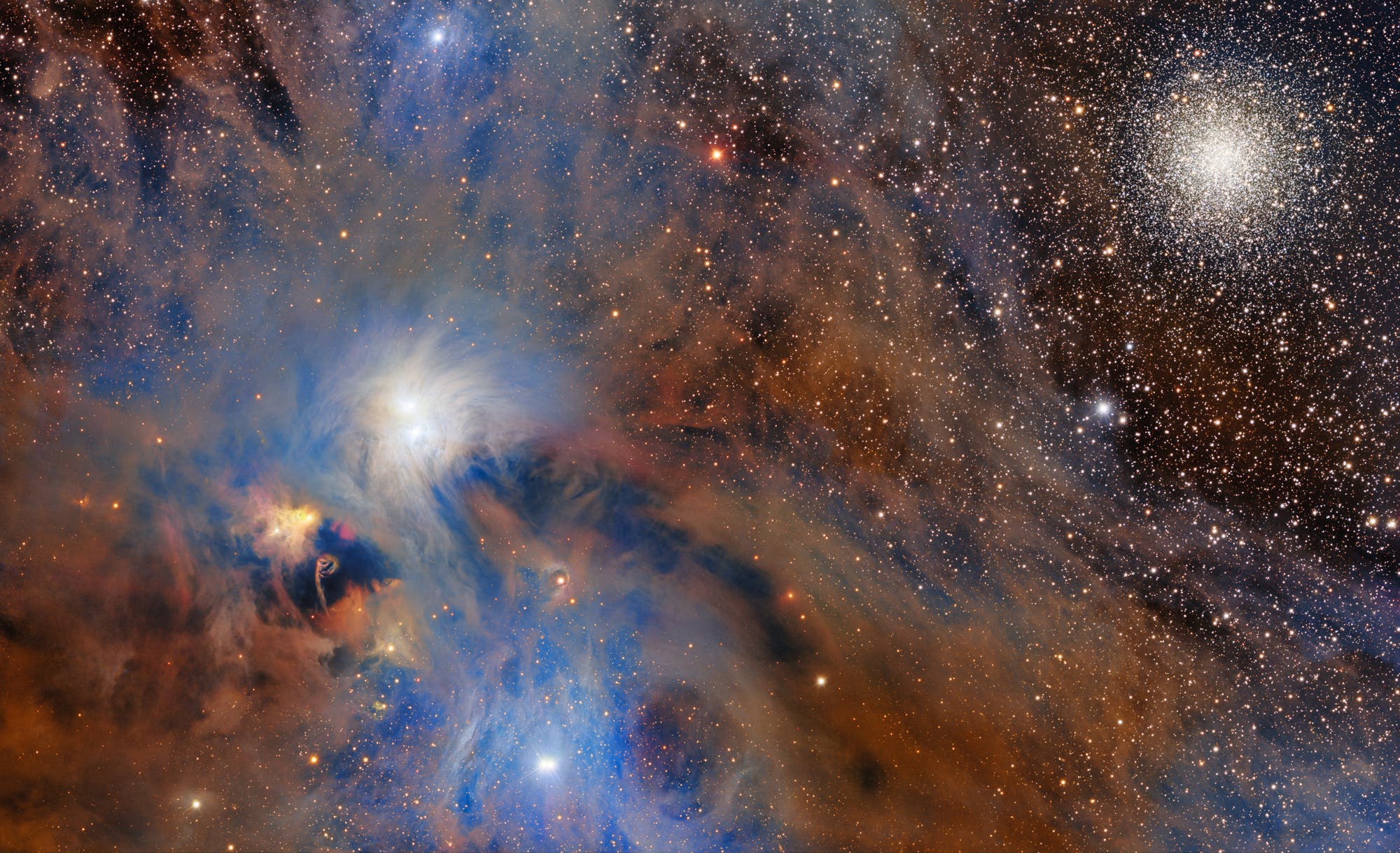 Ein farbenprächtiges astronomisches Bild zeigt eine dichte Ansammlung von Sternen und interstellaren Wolken. Links im Bild ist eine helle, leuchtende Region mit blauen und orangefarbenen Nebeln zu sehen, die von dunklen Staubwolken durchzogen sind. Rechts oben befindet sich ein kugelförmiger Sternhaufen, der aus zahlreichen dicht gepackten Sternen besteht. Die Szene vermittelt die Weite und Komplexität des Universums. Ein farbenprächtiges astronomisches Bild zeigt eine dichte Ansammlung von Sternen und interstellaren Wolken. Links im Bild ist eine helle, leuchtende Region mit blauen und orangefarbenen Nebeln zu sehen, die von dunklen Staubwolken durchzogen sind. Rechts oben befindet sich ein kugelförmiger Sternhaufen, der aus zahlreichen dicht gepackten Sternen besteht. Die Szene vermittelt die Weite und Komplexität des Universums.