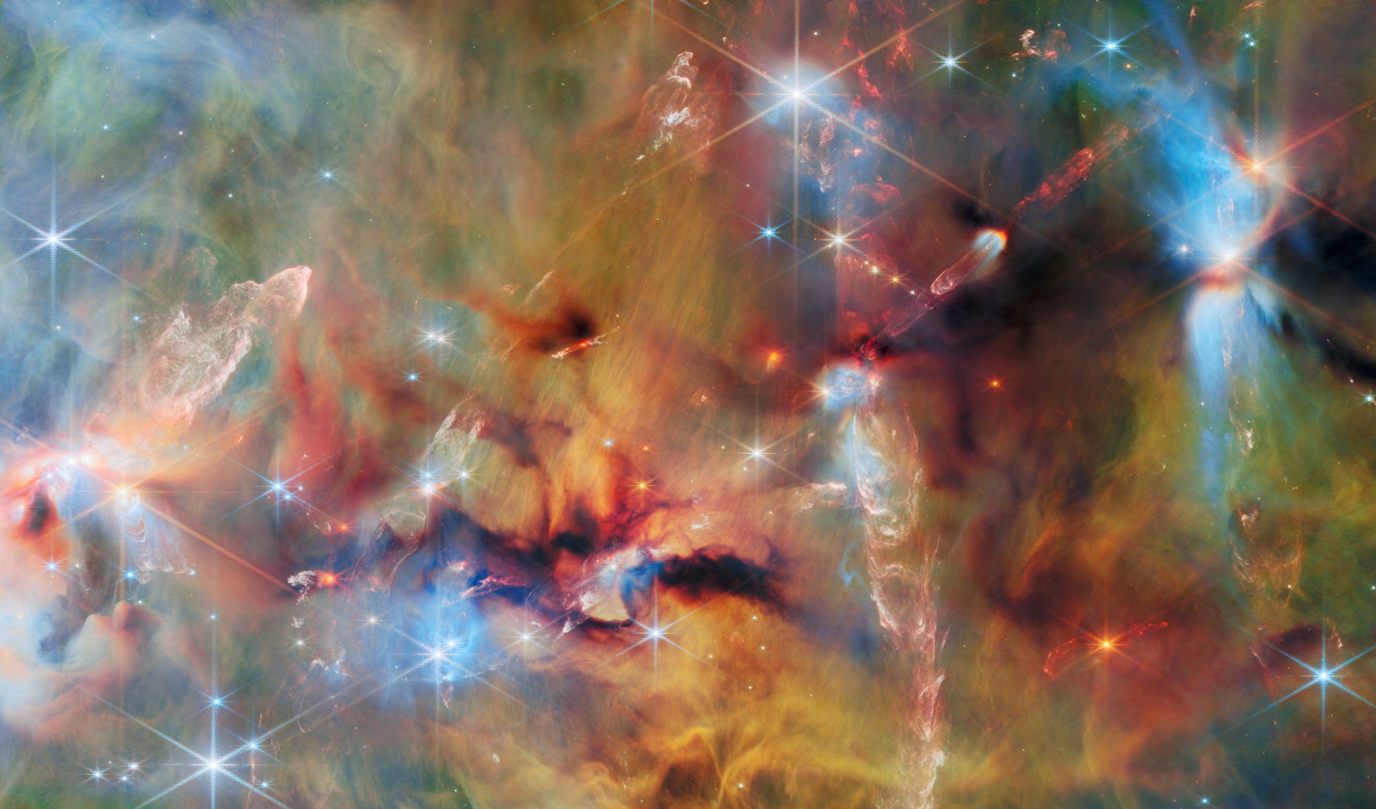Ein farbenfrohes astronomisches Bild zeigt eine dichte Ansammlung von Sternen und leuchtenden Gaswolken im Weltraum. Verschiedene Farben wie Blau, Rot und Gelb mischen sich und bilden ein komplexes Muster aus Nebeln und Licht. Helle Sterne mit Lichtstrahlen sind über das Bild verteilt, während die Gaswolken in unterschiedlichen Formen und Intensitäten leuchten. Das Bild vermittelt die Weite und Schönheit des Universums. Ein farbenfrohes astronomisches Bild zeigt eine dichte Ansammlung von Sternen und leuchtenden Gaswolken im Weltraum. Verschiedene Farben wie Blau, Rot und Gelb mischen sich und bilden ein komplexes Muster aus Nebeln und Licht. Helle Sterne mit Lichtstrahlen sind über das Bild verteilt, während die Gaswolken in unterschiedlichen Formen und Intensitäten leuchten. Das Bild vermittelt die Weite und Schönheit des Universums.