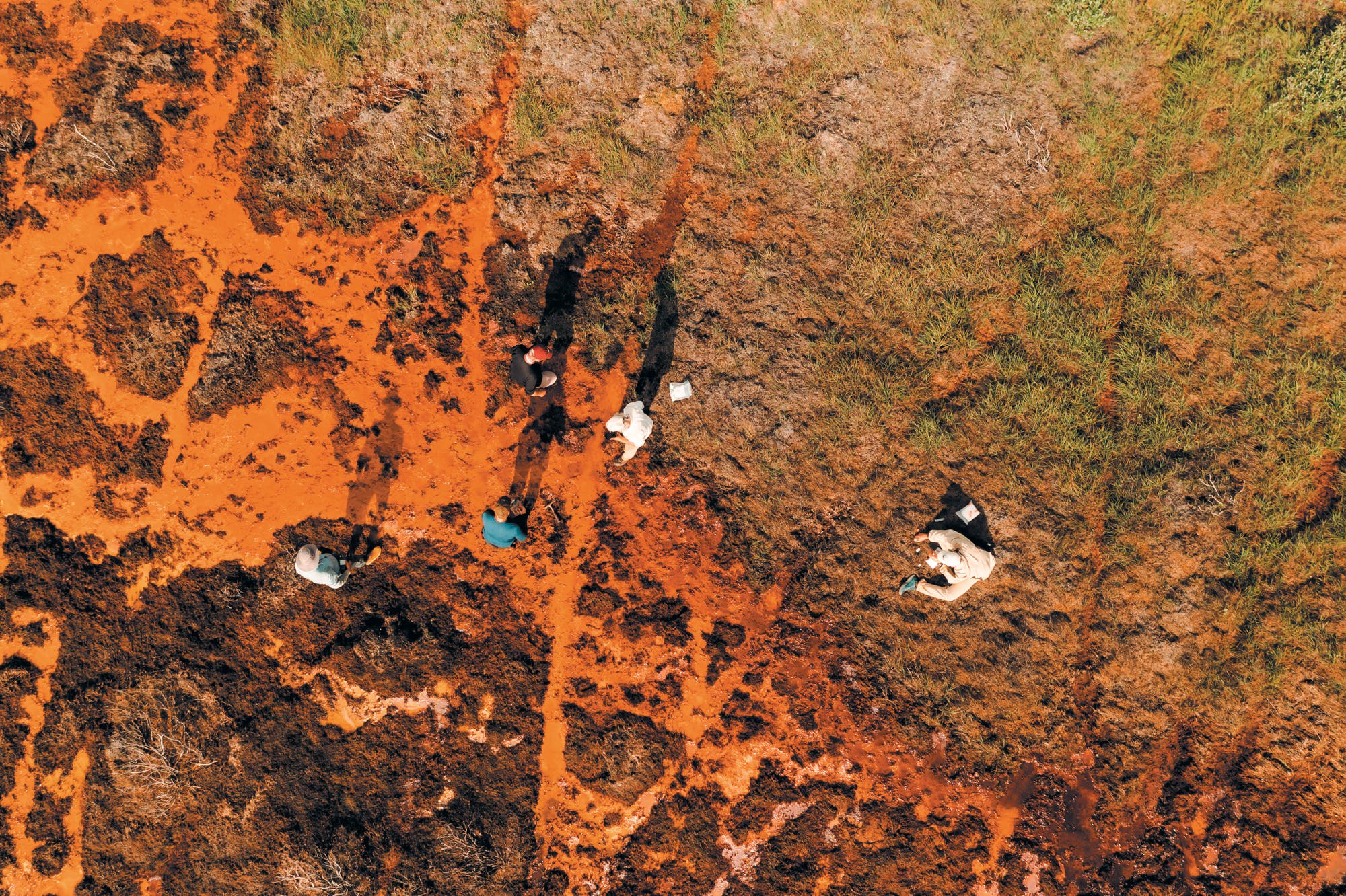 Luftaufnahme: rot-orangene Brühe eins Flusses hat den Boden ringsum zerstört