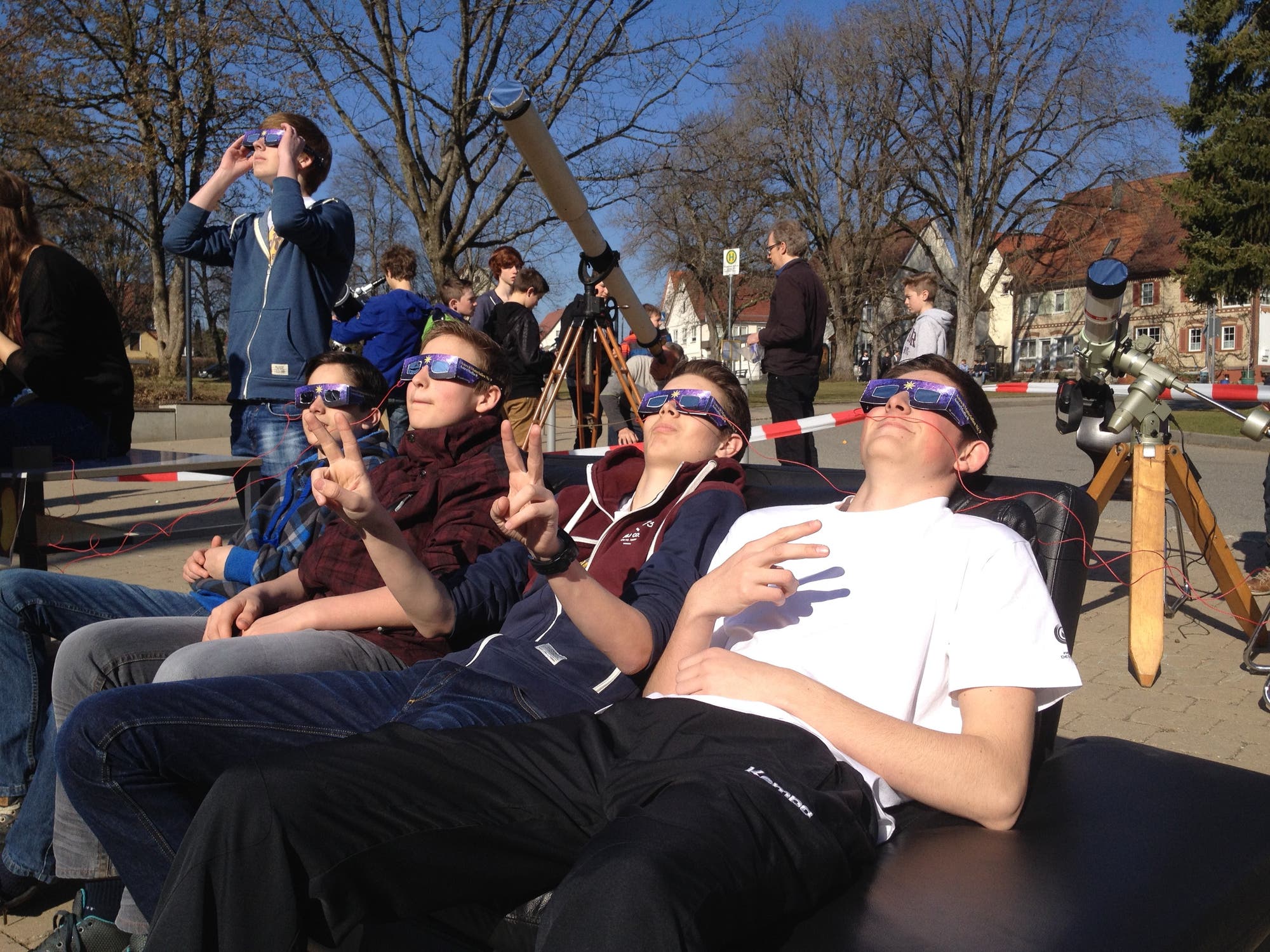 Schüler mit Sonnensichtbrillen beobachten eine Sonnenfinsternis
