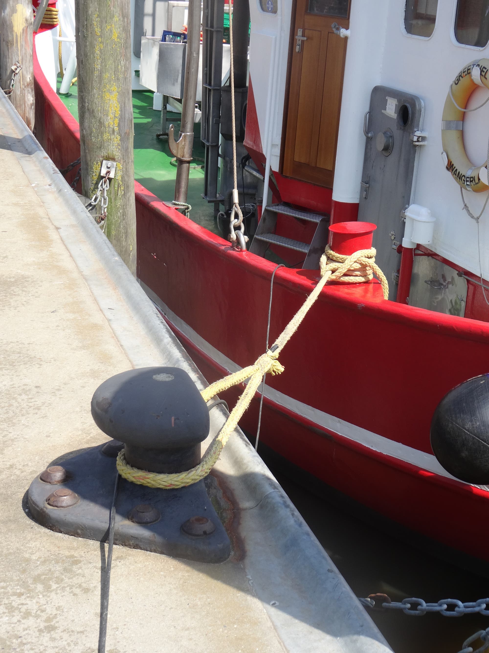 Ein Schiff ist an einem Kai mit einem Seil festgemacht