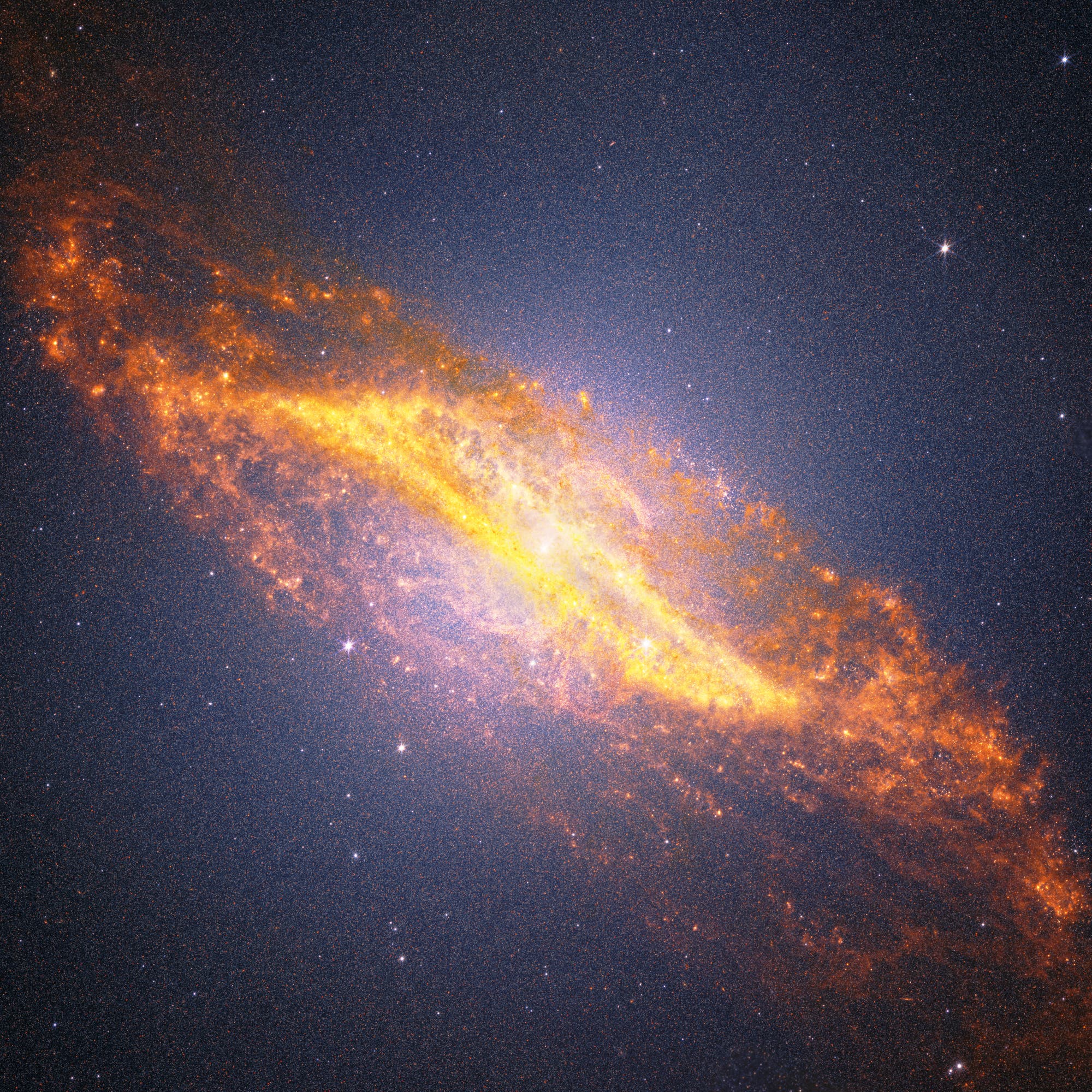Eine farbenfrohe astronomische Aufnahme einer Spiralgalaxie, die sich diagonal durch das Bild erstreckt. Die Galaxie zeigt leuchtende, orangefarbene und gelbe Bereiche, die auf aktive Sternentstehung hinweisen, umgeben von einem dunklen, sternenübersäten Hintergrund. Die Struktur der Galaxie ist deutlich sichtbar, mit einem hellen Zentrum und ausgedehnten Spiralarmen. Das Bild vermittelt die Weite und Schönheit des Universums. Eine farbenfrohe astronomische Aufnahme einer Spiralgalaxie, die sich diagonal durch das Bild erstreckt. Die Galaxie zeigt leuchtende, orangefarbene und gelbe Bereiche, die auf aktive Sternentstehung hinweisen, umgeben von einem dunklen, sternenübersäten Hintergrund. Die Struktur der Galaxie ist deutlich sichtbar, mit einem hellen Zentrum und ausgedehnten Spiralarmen. Das Bild vermittelt die Weite und Schönheit des Universums.