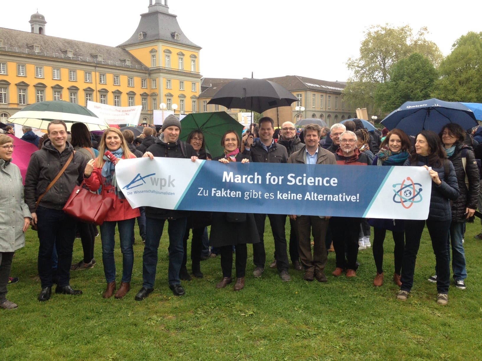 Wissenschaftsjournalisten präsentieren das Banner des Science March vor dem Gebäude der Uni Bonn.