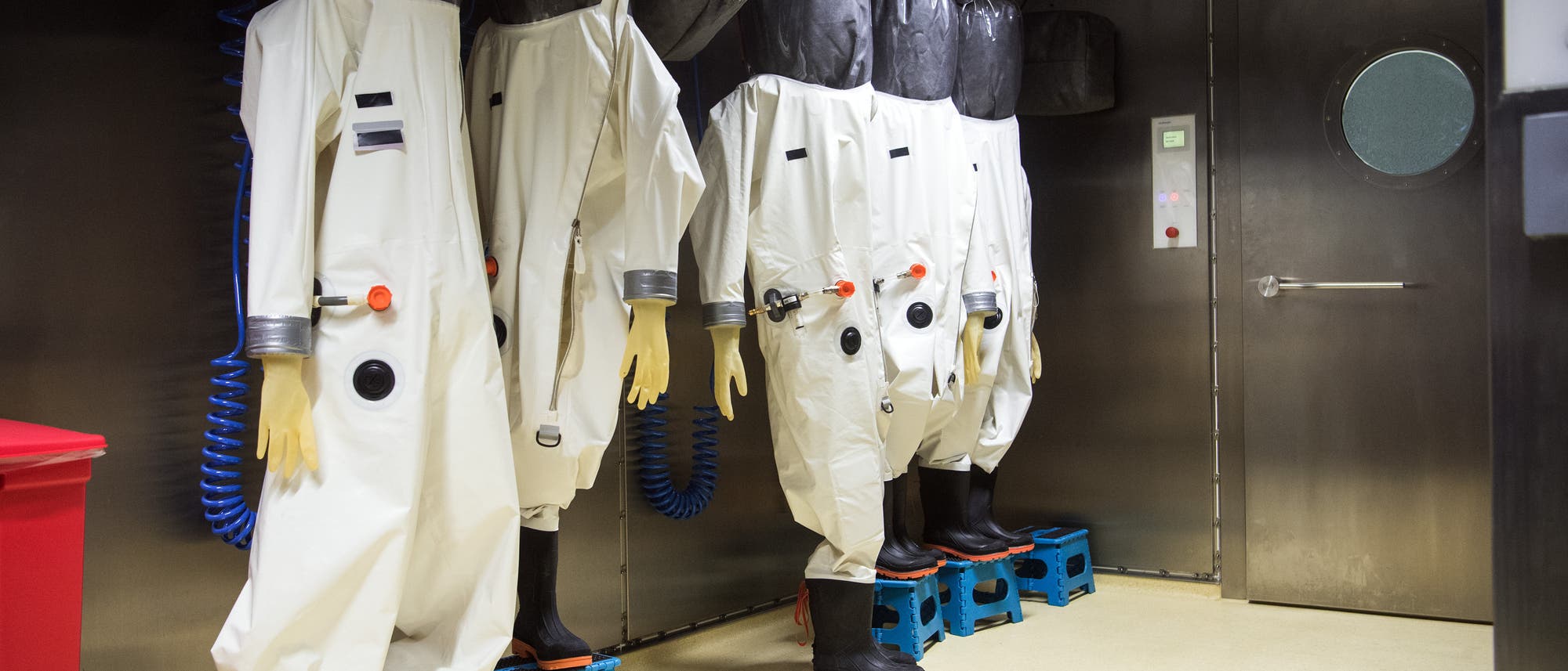 Schutzanzüge hängen im Anzugraum des S4-Labors im Robert Koch-Institut (RKI). In dem Labor der höchsten Schutzstufe vier können Mitarbeiterinnen und Mitarbeiter hochansteckende, lebensbedrohliche Krankheitserreger wie Ebola-, Lassa- oder Nipah-Viren sicher untersuchen. (Archiv)